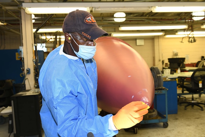 man apply putty to aircraft nose cone