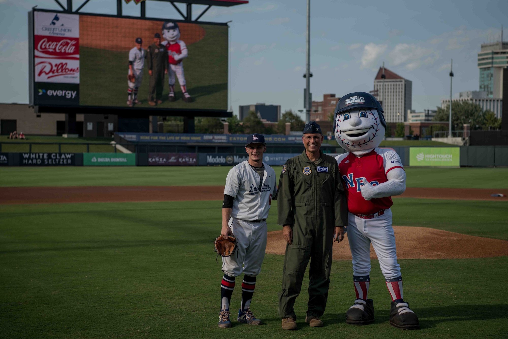 Col. Nate Vogel, 22nd Air Refueling Wing commander (center), poses for a photo with Max Puls, Lonestar Baseball Club first baseman (left), and the National Baseball Congress World Series mascot before the ball game, Aug. 19, 2021, in Wichita, Kansas. The NBC World Series held their annual tournament in Kansas, and finished with championship week at Riverfront Stadium in Wichita, Kansas. (U.S. Air Force photo by Senior Airman Marc A. Garcia)