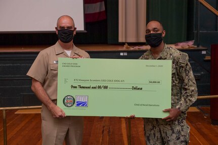 NAVAL STATION NORFOLK (Aug. 11, 2021) Rear Adm. Brendan McLane, commander, Naval Surface Force Atlantic, left, presents a CNO Gold Disk Awards Program payment to Electronics Technician 2nd Class Kwayon Sconiers, assigned to the guided-missile destroyer USS Cole (DDG 67). Sconiers was a Fiscal Year-20, 4th Quarter awardee for the CNO Gold Disk Awards Program, highlighting Sailors who excel in the 2M repair field. (U.S. Navy photo by Mass Communication Specialist 1st Class Jacob Milham)