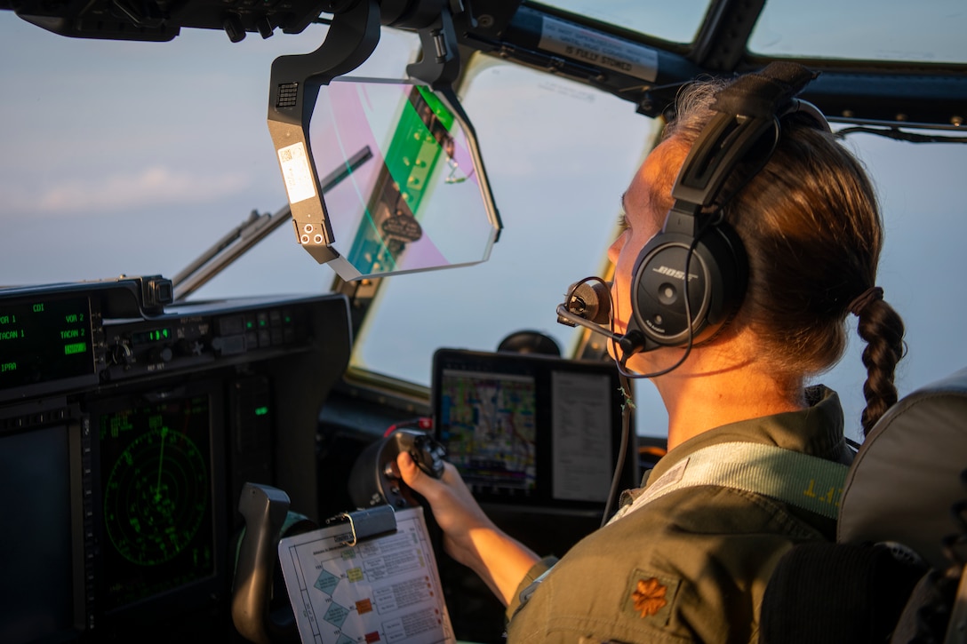 An airman looks ahead as she pilots an aircraft.