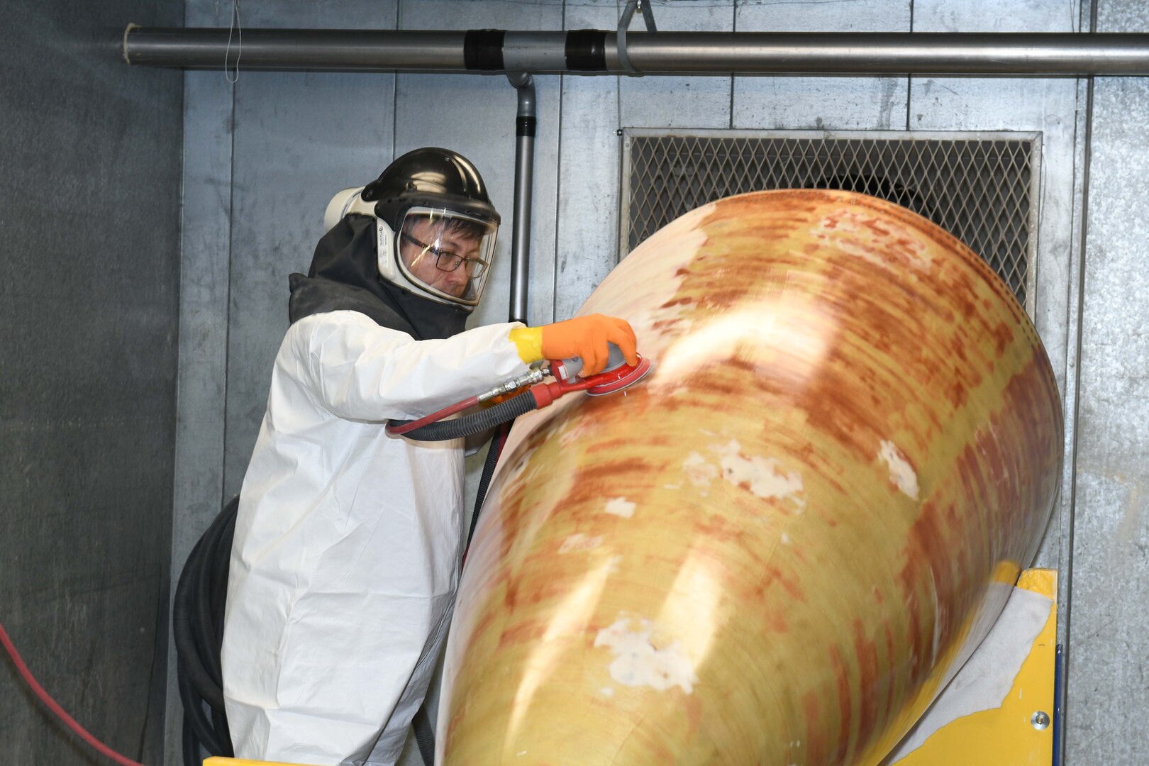 man sanding aircraft nose cone