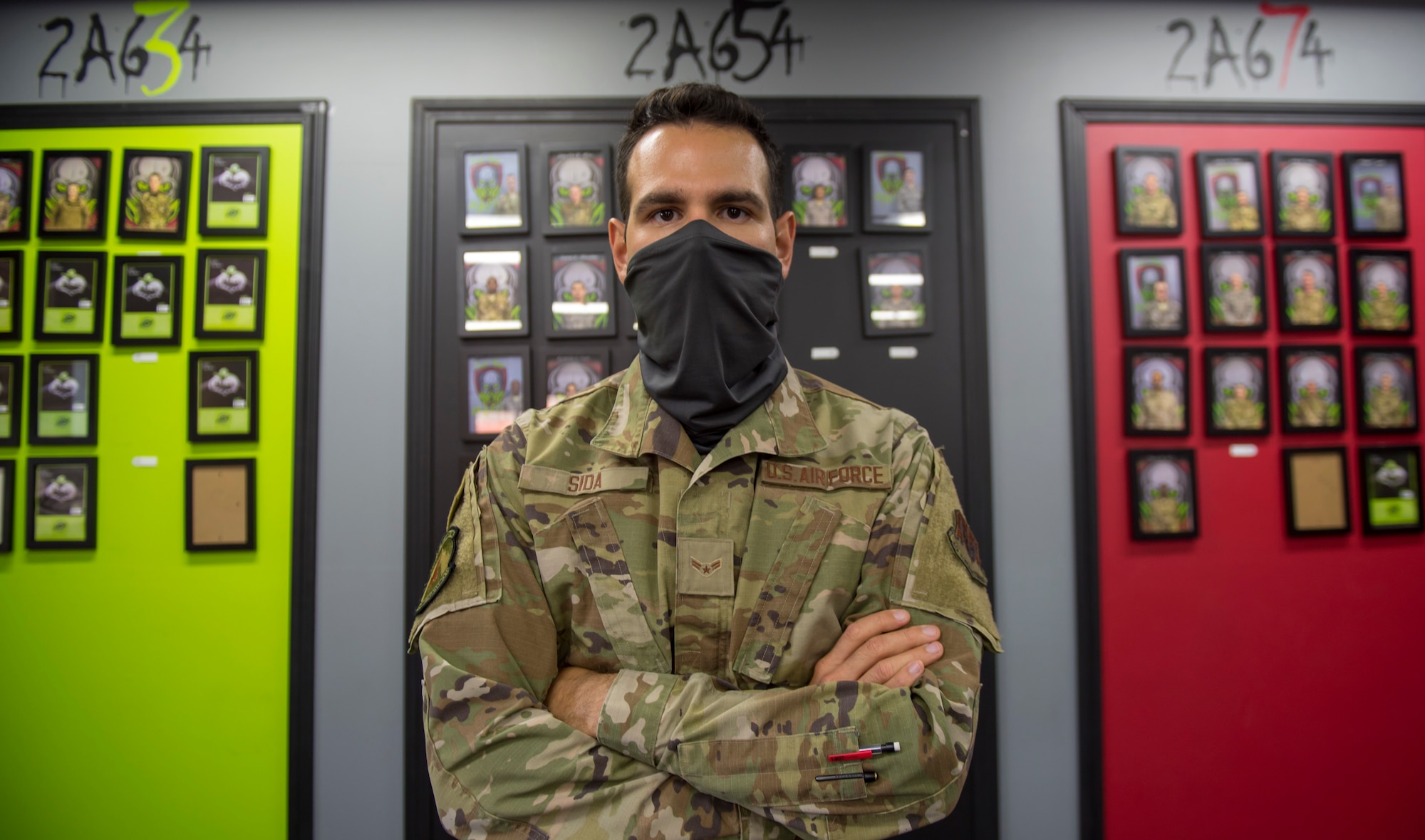 An airman poses cross-armed for an official portrait