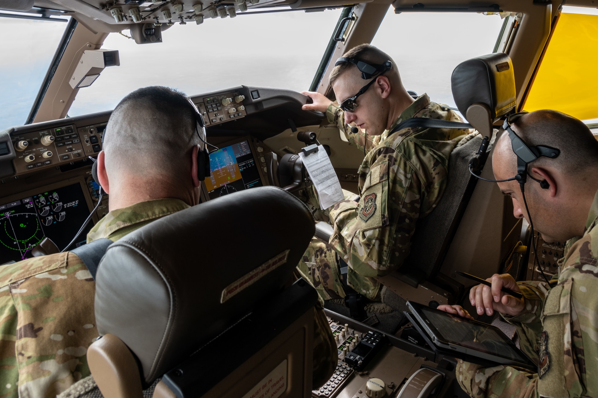 (From left) Lt. Col. Joshua Moores, 344th Air Refueling Squadron commander, 1st Lt. Brandon Sweet, 344th ARS KC-46A Pegasus pilot, and Senior Master Sgt. Lindsay Moon, 22nd Operations Group senior enlisted manager, review drogue procedures in preparation to refuel F/A-18 Hornets from Marine Fighter Attack Squadron 112, Fort Worth, Texas, Aug. 11, 2021.