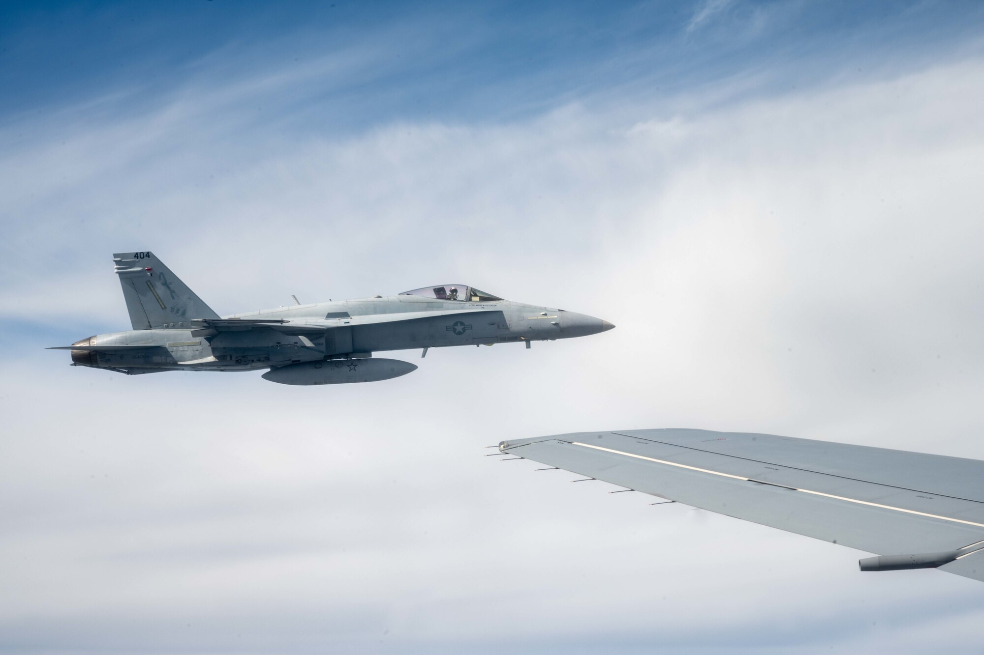F/A-18 Hornets from Marine Fighter Attack Squadron 112, Fort Worth, Texas, fly in formation with a KC-46A Pegasus from the 22nd Air Refueling Wing, McConnell Air Force Base, Kansas, after being refueled by the aircraft Aug. 11, 2021.