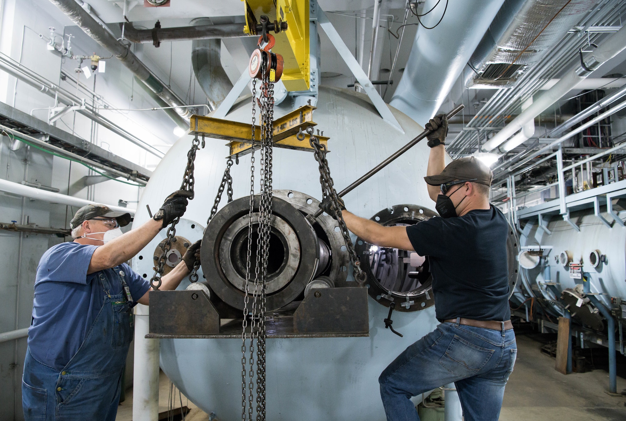 Greg Smartt, left, and Tim Mullins, Arnold Engineering Development Complex machinists, rotate a connection assembly into place on the end of the 8-inch barrel for the Hyper-ballistic Range G gun at Arnold Air Force Base, Tenn., March 19, 2021. The barrel consists of several sections that have to be connected and perfectly aligned. (U.S. Air Force photo by Jill Pickett)