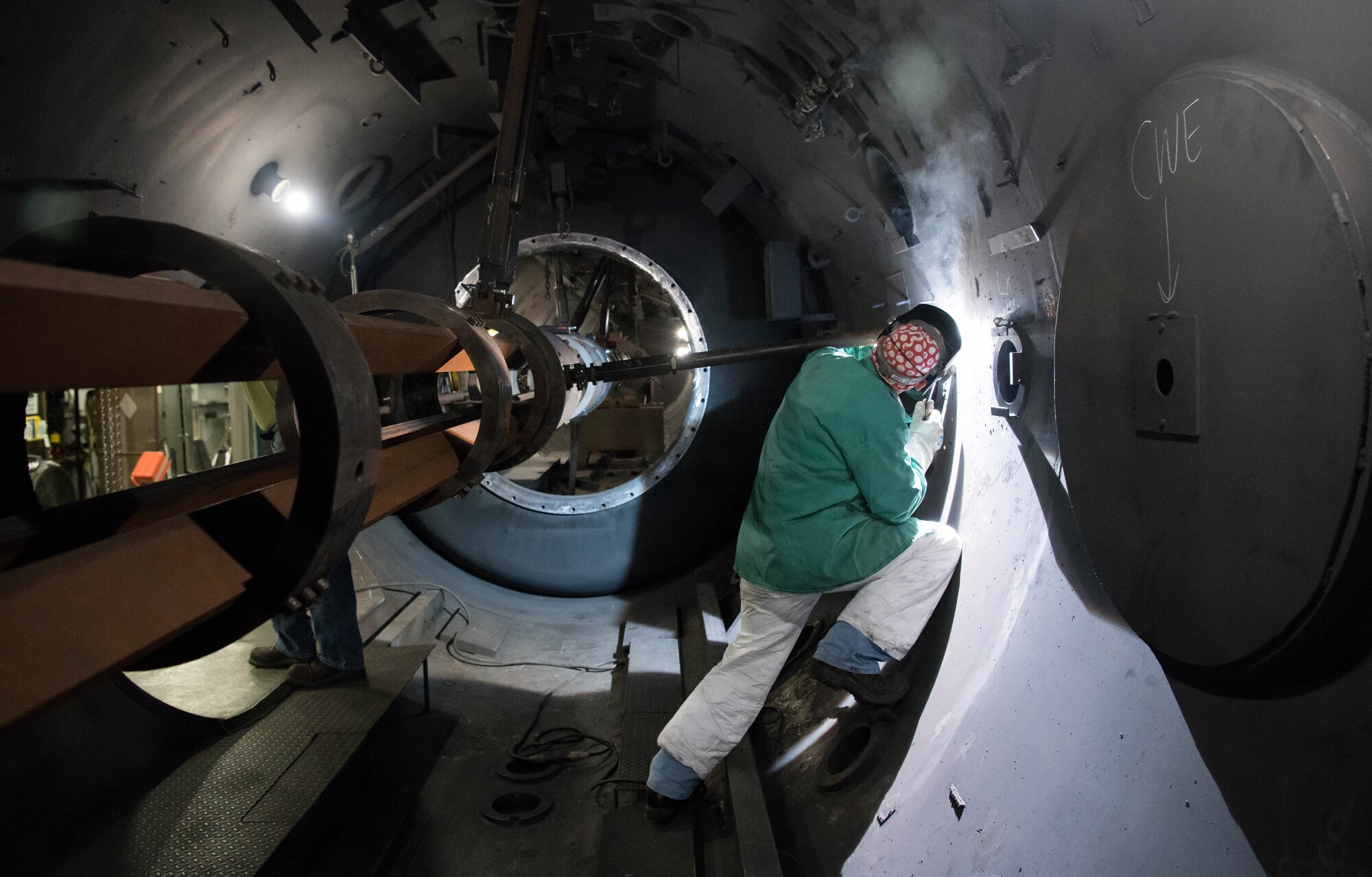 Troy Caldwell, an Arnold Engineering Development Complex boilermaker, welds an arm of the 8-inch track for the Hyper-ballistic Range G gun to the side of the test tank May 3, 2021, at Arnold Air Force Base, Tenn. The arms hold the track in place but allow for recoil. (U.S. Air Force photo by Jill Pickett)