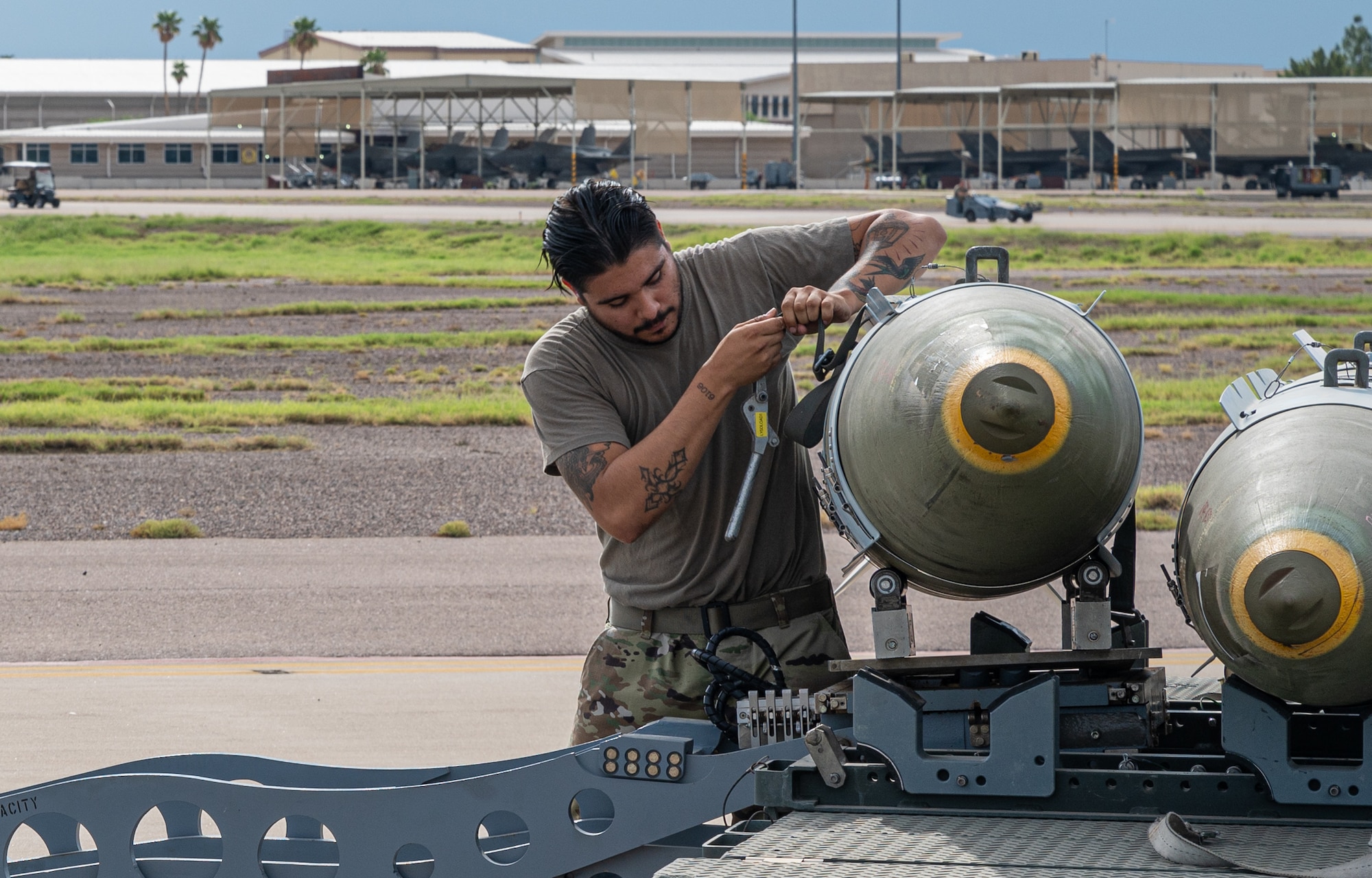 U.S. Air Force Staff Sgt. Nikolas Ramirez, 61st Aircraft Maintenance Unit maintainer, secures a GBU-31 joint direct attack munition onto a munition jammer Aug. 9, 2021, at Luke Air Force Base, Arizona.
