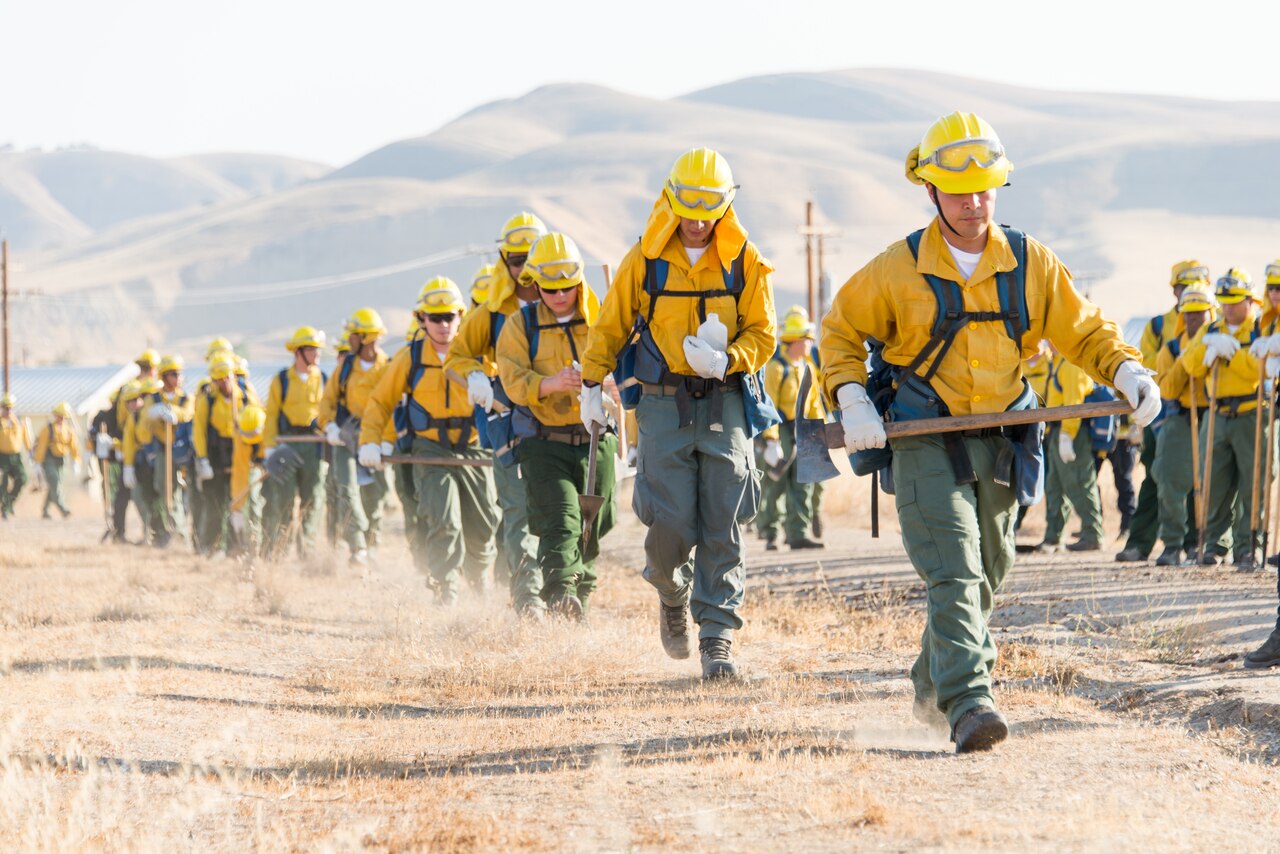 A large group of guardsmen walk down a dirt road.