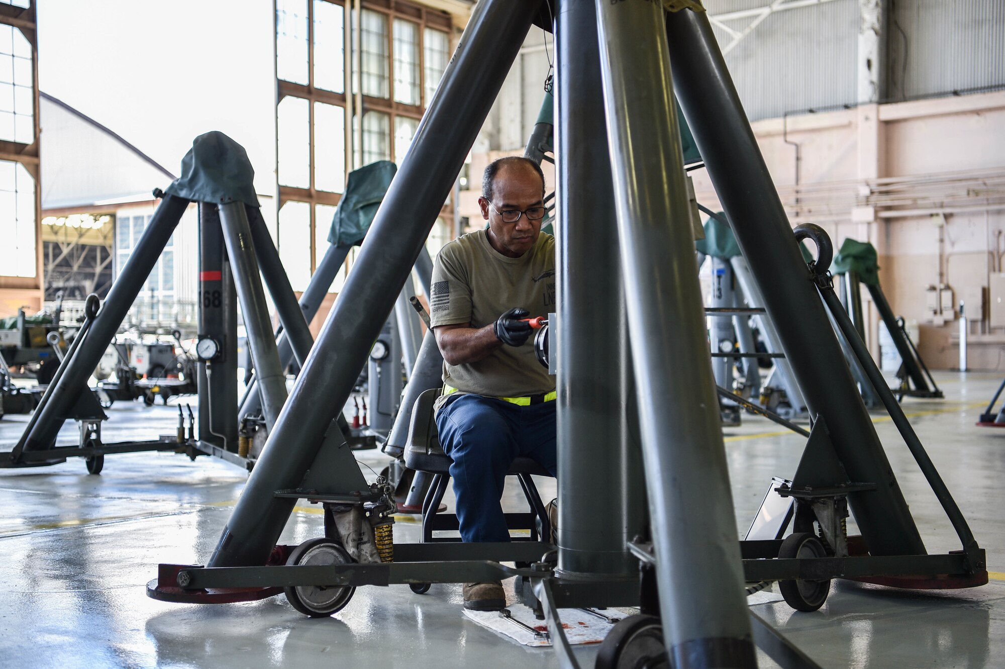Amnadth Hamilton, 15th Maintenance Squadron aerospace ground equipment powered support systems mechanic, disconnects a 60-ton aircraft jack pressure gauge in Hangar 15 at Joint Base Pearl Harbor-Hickam, Hawaii, Aug. 12, 2021. More than 30 AGE personnel provide 24/7 mission support, supplying equipment to sustain continuous JBPHH flight operations. (U.S. Air Force photo by Senior Airman Alan Ricker)