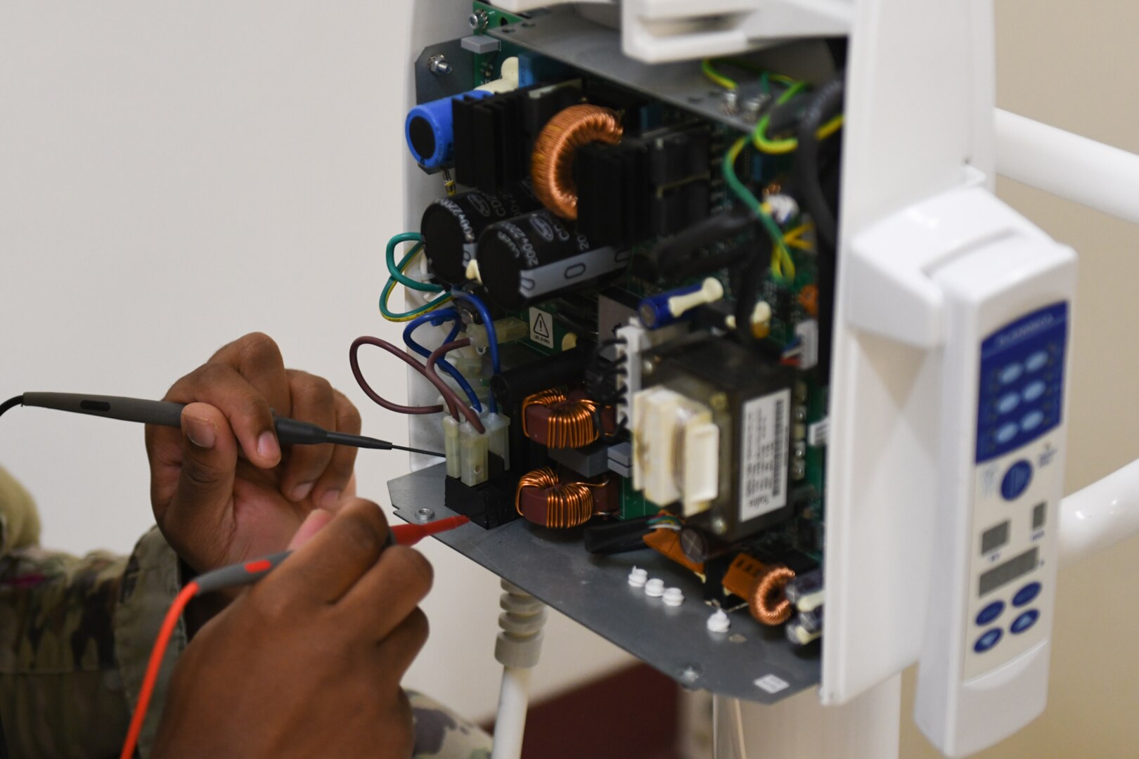 A Biomedical Equipment Technician program student troubleshoots medical equipment at the Medical Education and Training Campus.