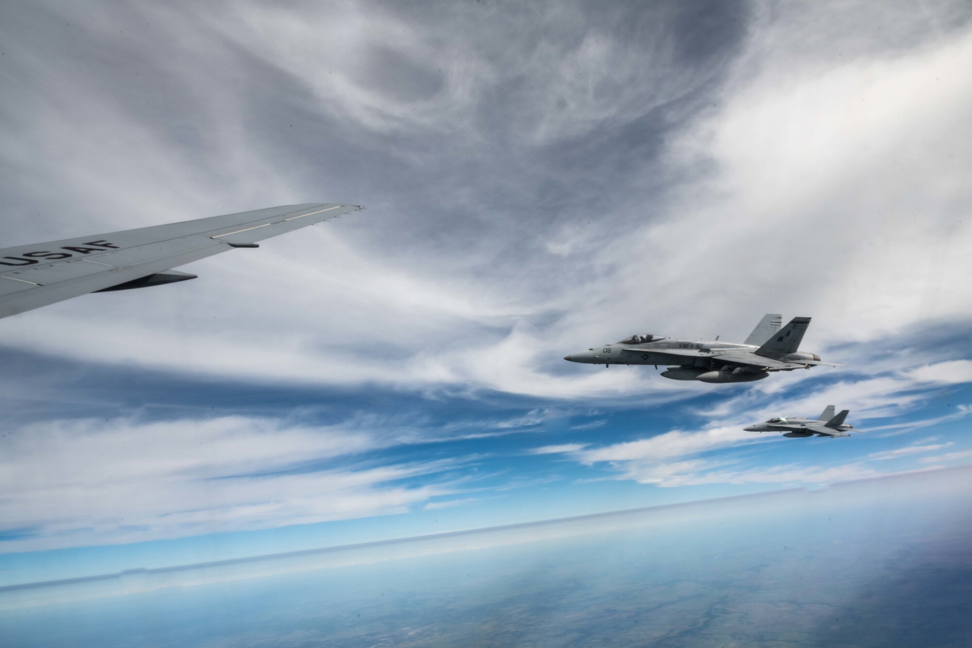 An F/A-18 Hornet from Marine Fighter Attack Squadron 112, Fort Worth, Texas, flies in formation with a KC-46A Pegasus from the 22nd Air Refueling Wing, McConnell Air Force Base, Kansas, while awaiting fuel Aug. 11, 2021.