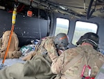 Staff Sgt. Damion Minchaca, left, an Alaska Army National Guard flight paramedic, and Spc. Stefano James, a UH-60L Black Hawk medevac helicopter crew chief, provide critical care to a 75-year-old man after he fell into a river and stopped breathing Aug. 12, 2021. The crew, from Detachment 2, G Company, 2nd Battalion, 211th Aviation Regiment, hoisted the patient into the aircraft and flew him to a hospital after he was revived by a fishing guide.