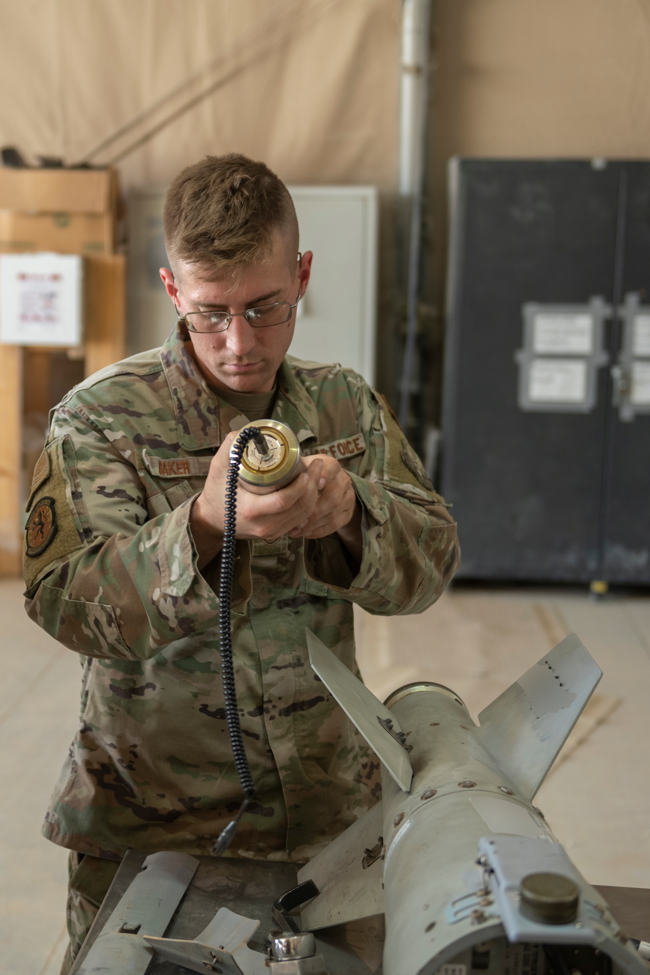 U.S. Air Force Staff Sgt. Samuel Baker, 332nd Expeditionary Maintenance Squadron production crew chief, assembles a guided bomb unit August 14, 2021, in an undisclosed location somewhere in Southwest Asia. The 332nd EMXS creates and maintains the equipment use to execute missions across the area of responsibility. (U.S. Air Force Senior Airman Cameron Otte) (This image is blurred for security reasons)