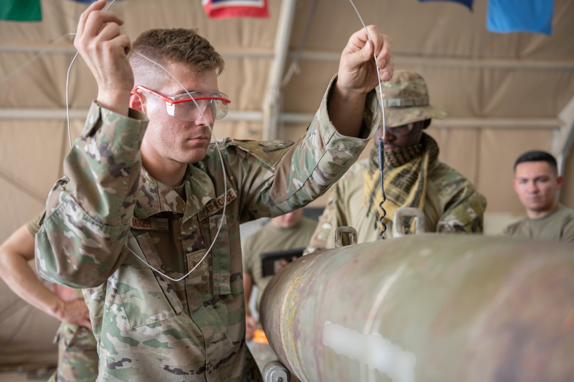 U.S. Air Force Staff Sgt. Samuel Baker, 332nd Expeditionary Maintenance Squadron production crew chief, assembles a guided bomb unit August 14, 2021, in an undisclosed location somewhere in Southwest Asia. The 332nd EMXS creates and maintains the equipment use to execute missions across the area of responsibility. (U.S. Air Force Senior Airman Cameron Otte) (This image is blurred for security reasons)