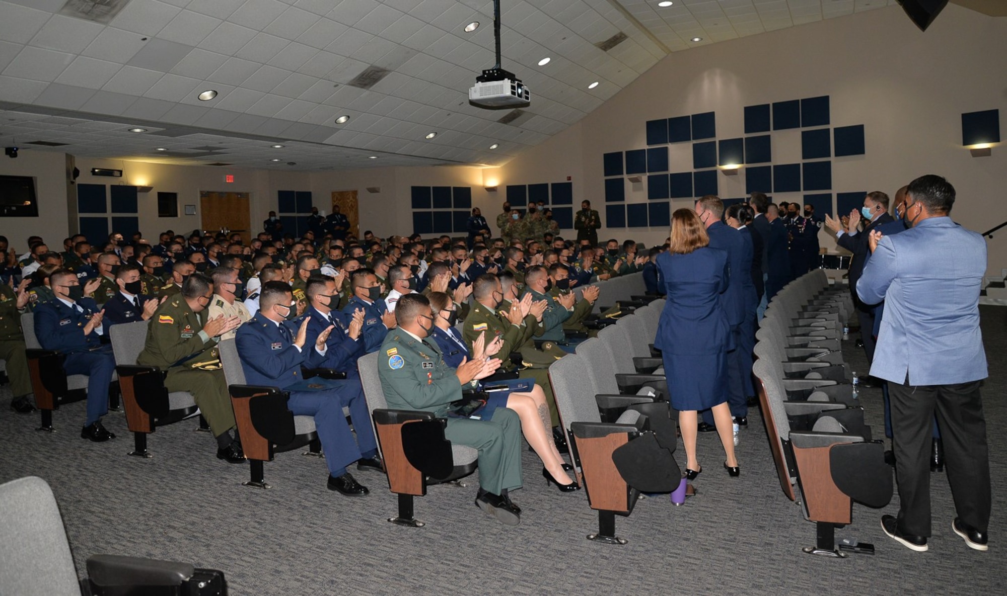 Leaders stand and applaud members of class.