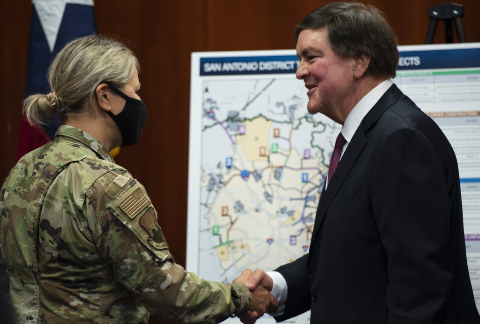 A man and woman shake hands after a press conference in San Antonio.