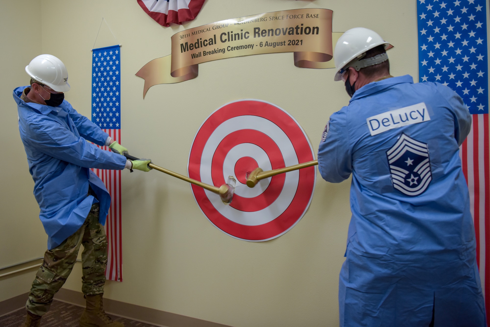 Col. Robert Long, Space Launch Delta 30 commander, and CMSgt. Jason DeLucy, Command Chief Master Sergeant of Space Launch Delta 30, begin the wall breaking ceremony Aug. 6, 2021, at the 30th Medical Group building on Vandenberg Space Force Base, California.