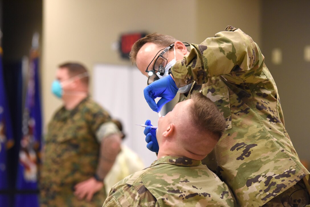 U.S. Air Force Lt. Col. Chris Sampair, chief dentist, 110th Medical Group, Michigan Air National Guard conducts a dental exam during a joint dental clinic involving dental teams from the 110th Medical Group and the 4th Dental Battalion, 4th Marine Logistics Group, held at the 110th Wing, Battle Creek Air National Guard Base, Battle Creek, Michigan, Aug. 7, 2021. With the focus on readiness in a joint environment, the 110th Wing hosted a joint dental clinic involving dental teams from the 110th Medical Group and the 4th Dental Battalion, 4th Marine Logistics Group. (U.S. Air National Guard photo by Master Sgt. David Eichaker)