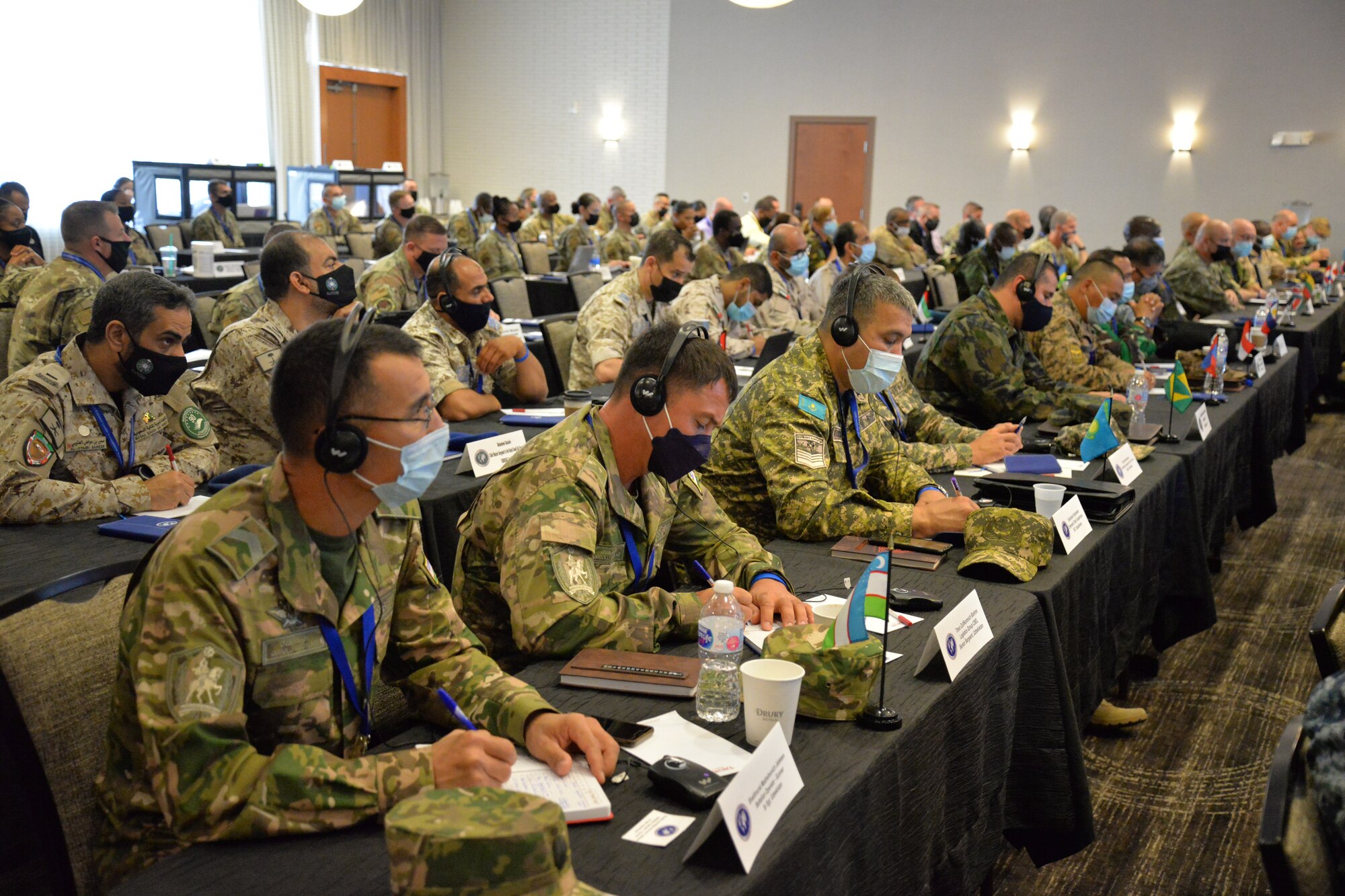 People sitting at tables, some with headphones on.