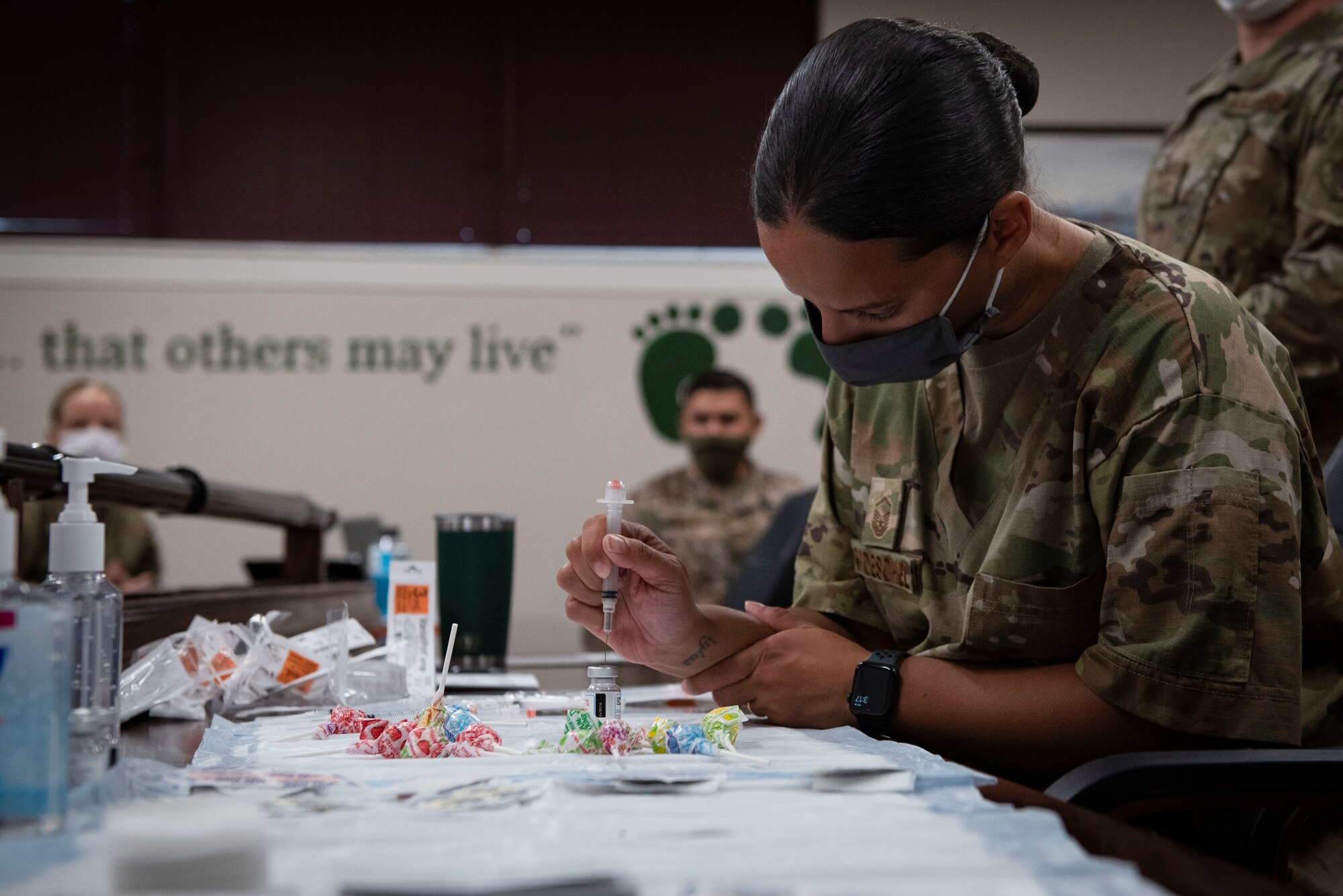 A photo of an Airman filling up syringes.