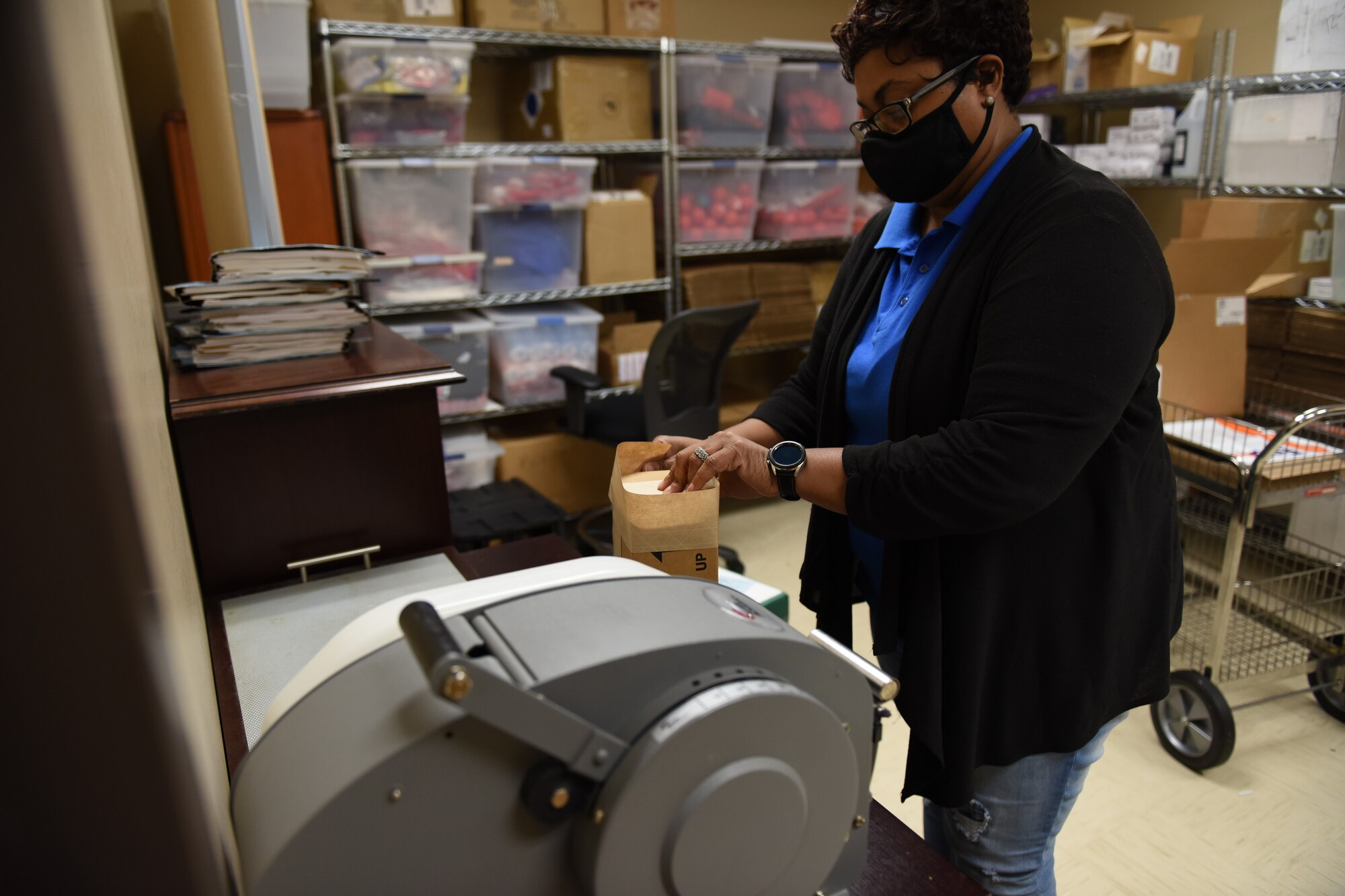 Photo shows woman putting sample cup into a bag.