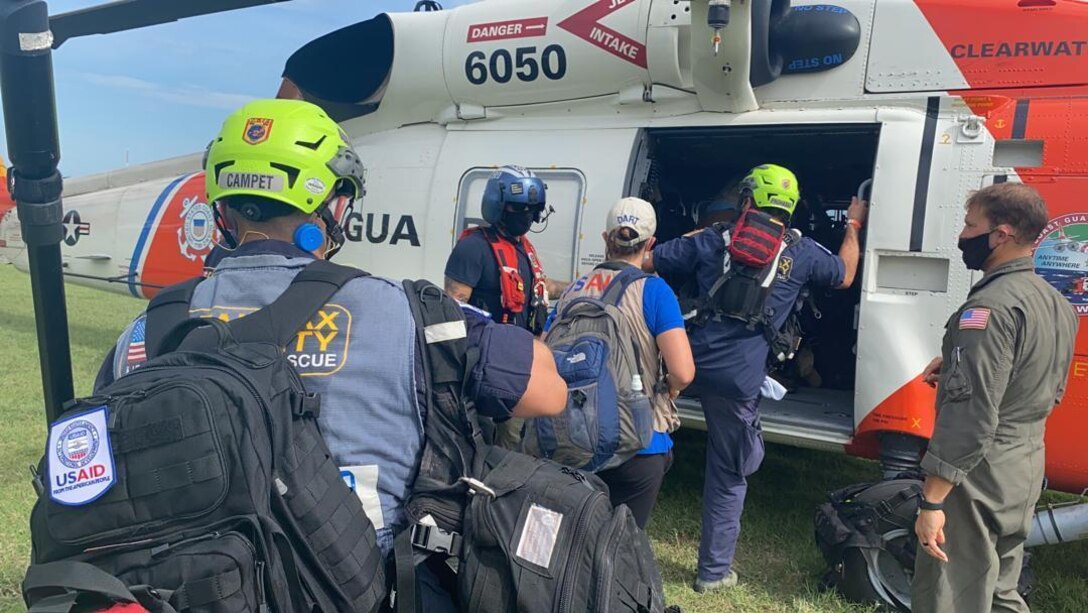 A U.S. Coast Guard Air Station Clearwater helicopter crew embarks members from an urban search and rescue crew in Fairfax, Va. Aug. 16, 2021