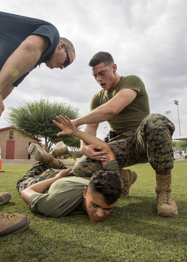 A U.S. Marine with the Provost Marshal Office apprehends a suspect during oleoresin capsicum spray training on Marine Corps Air Station Yuma, Ariz., July 30, 2021.