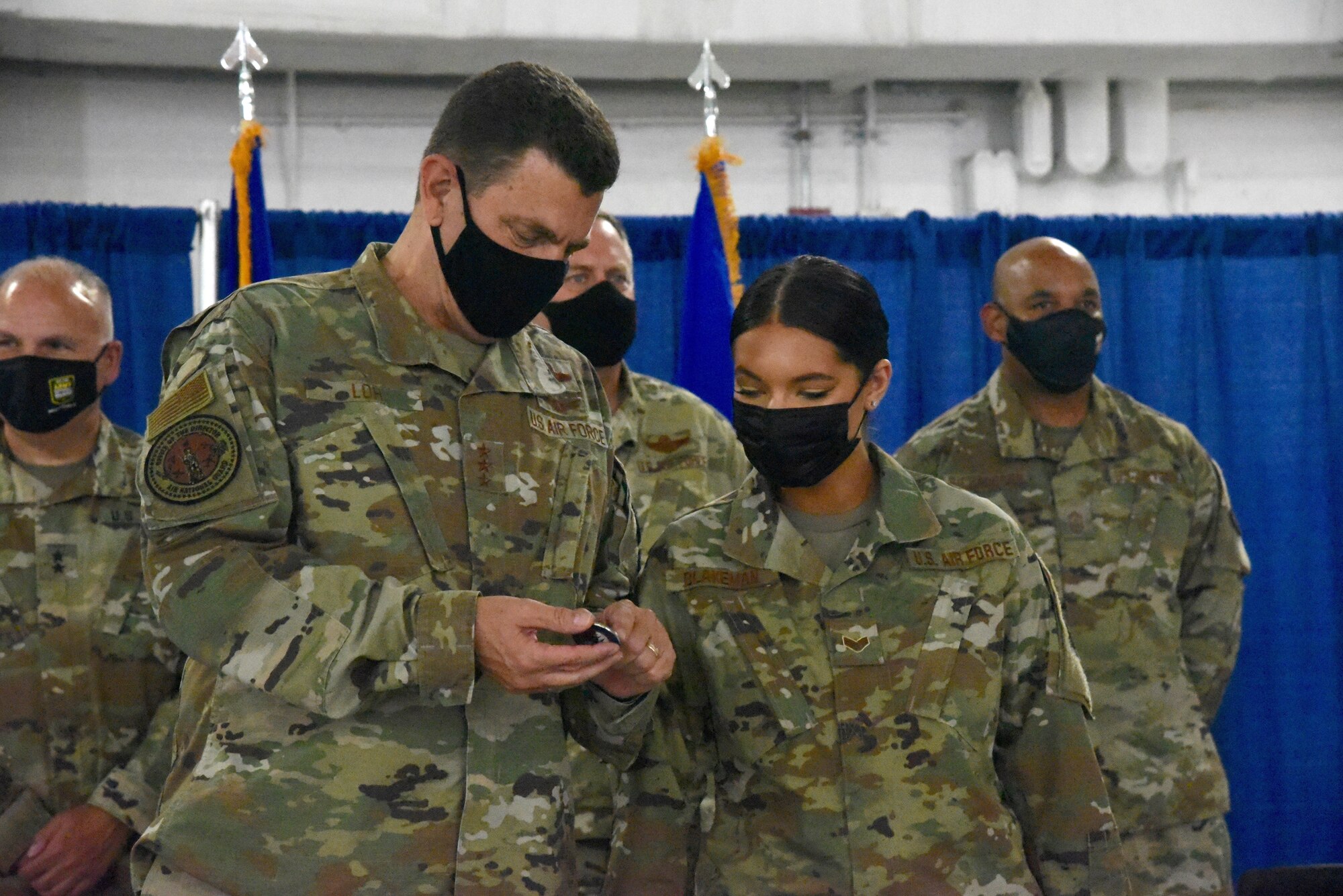 U.S. Air Force Lt. Gen. Michael A. Loh, director, Air National Guard, presents his coin to Senior Airman Paige Blakeman, Logistics Readiness Squadron, 174th Attack Wing, New York National Guard, during a visit to Hancock Field Air National Guard Base, Syracuse, New York, Aug. 7, 2021. Blakeman was recognized for her hard work and dedication in preparing equipment for exercise Northern Edge in Alaska. (U.S. Air National Guard photo by Staff Sgt. Megan Fowler)