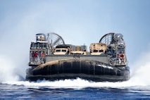 A Navy Marine Expeditionary Ship Interdiction System launcher, a command and control vehicle and a Joint Light Tactical Vehicle are transported by a U.S. Navy Landing Craft Air Cushion from Pacific Missile Range Facility Barking Sands, Hawaii, out to U.S.S. San Diego, Aug. 16, 2021. The movement demonstrated the mobility of a Marine Corps fires expeditionary advanced base, a core concept in the Marine Corps’ Force Design 2030 efforts. U.S. Navy and Marine Corps units came together from across 17 time zones as they participated in Large Scale Exercise 2021. (U.S. Marine Corps photo by Cpl. Luke Cohen, released)