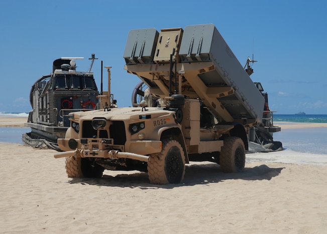 A Navy Marine Expeditionary Ship Interdiction System launcher deploys into position aboard Pacific Missile Range Facility Barking Sands, Hawaii, Aug. 16, 2021. The NMESIS and its Naval Strike Missiles participated in a live-fire exercise, here, part of Large Scale Exercise 2021. During the training, a Marine Corps fires expeditionary advanced base sensed, located, identified and struck a target ship at sea, which required more than 100 nautical miles of missile flight. The fires EAB Marines developed a targeting solution for a joint force of seapower and airpower which struck the ship as the Marines displaced to a new firing position. The Marine Corps EABO concept is a core component of the Force Design 2030 modernization effort. (U.S. Marine Corps photo by Maj. Nick Mannweiler, released)