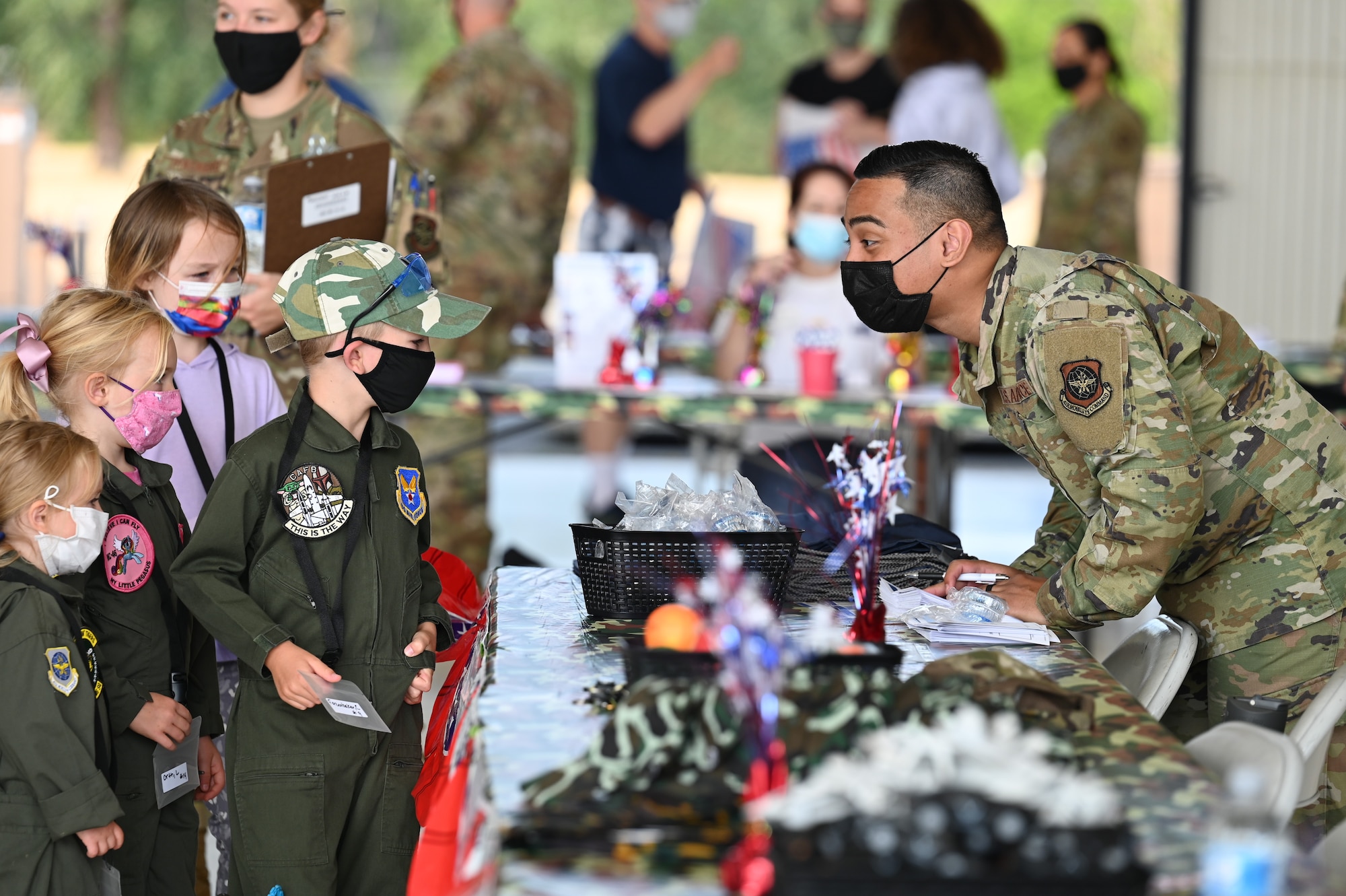 Team McChord children process through a simulated deployment line during Operation Kids Understanding Deployment Operations (KUDOs) at Joint Base Lewis-McChord, Washington, Aug. 14, 2021. The goal of the event is to provide a glimpse of what their military parents go through during deployments. (U.S. Air Force photo by Master Sgt. Julius Delos Reyes)