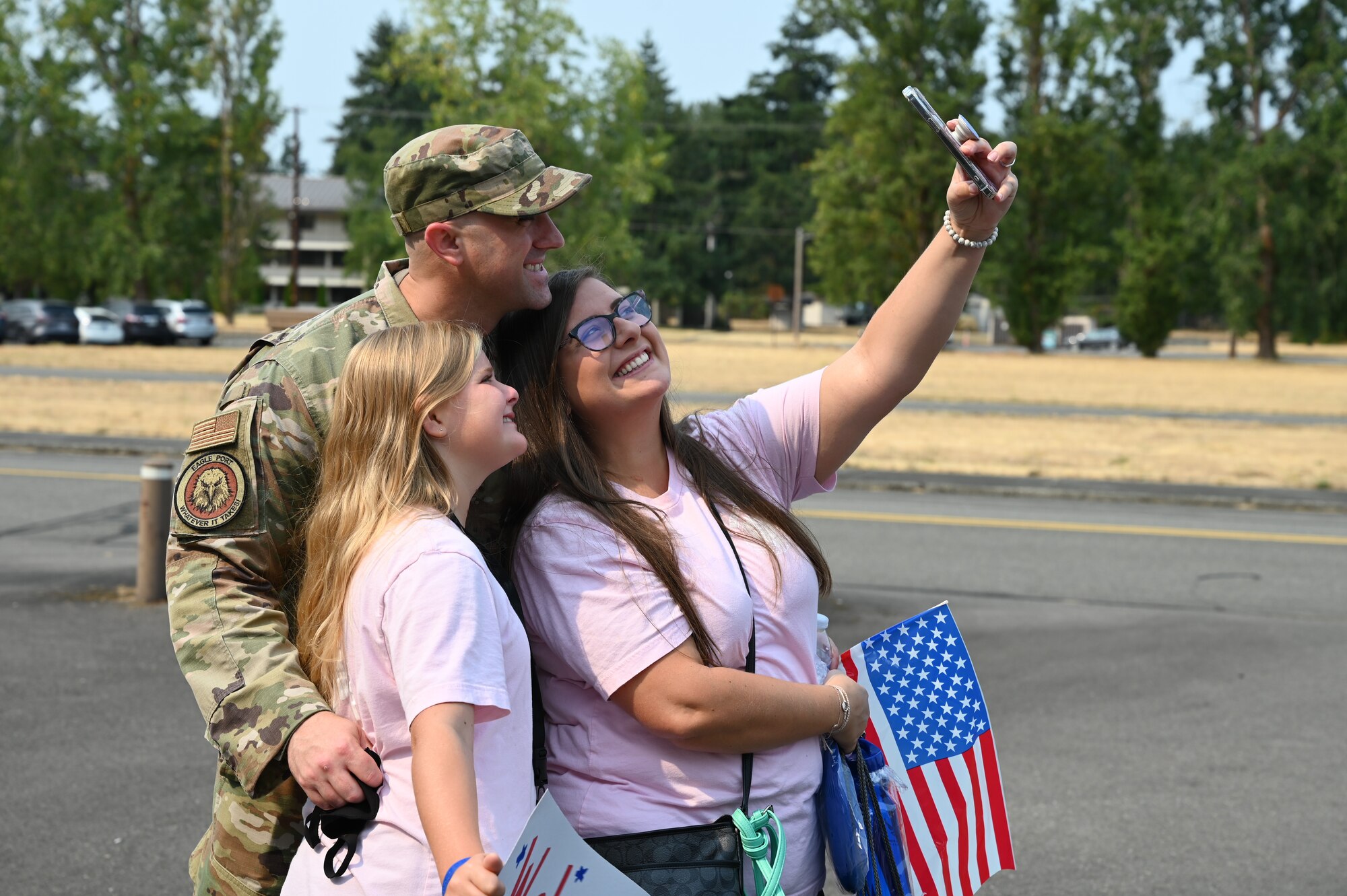 U.S. Air Force Senior Master Sgt. James Wall, 62nd APS senior enlisted leader, and his family, Christina and Leah, pose for a photo during Operation Kids Understanding Deployment Operations (KUDOs) at Joint Base Lewis-McChord, Washington, Aug. 14, 2021. More than 90 children, ages 4 to 14, participated in the mock deployment. (U.S. Air Force photo by Master Sgt. Julius Delos Reyes)