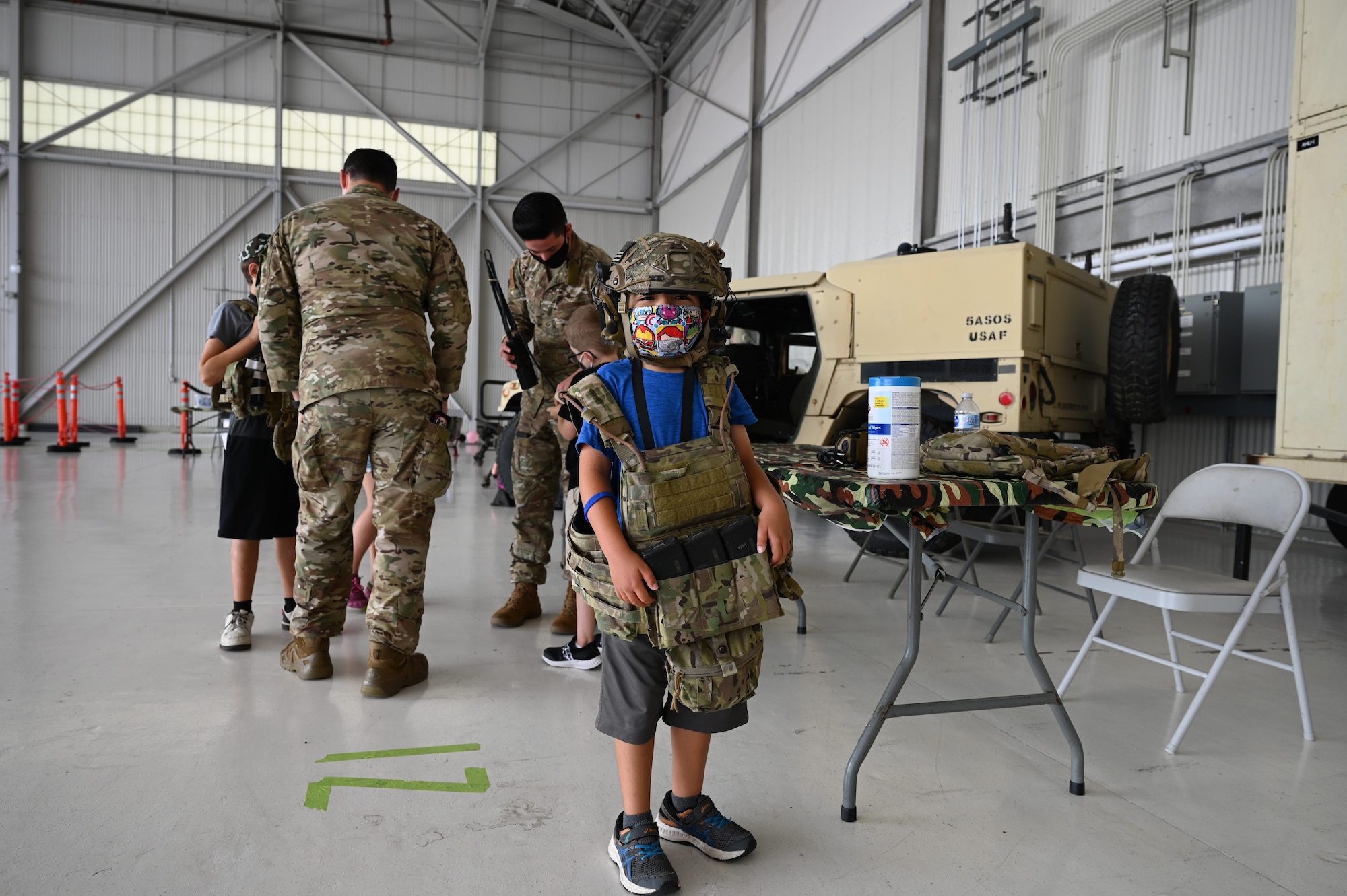 Mateo Vasquez-Gonzalez, 7, dons a helmet and vest during Operation Kids Understanding Deployment Operations (KUDOs) at Joint Base Lewis-McChord, Washington, Aug. 14, 2021. The children stopped at several stations including a C-17 Globemaster III static display, security forces and military working dog among others. (U.S. Air Force photo by Master Sgt. Julius Delos Reyes)