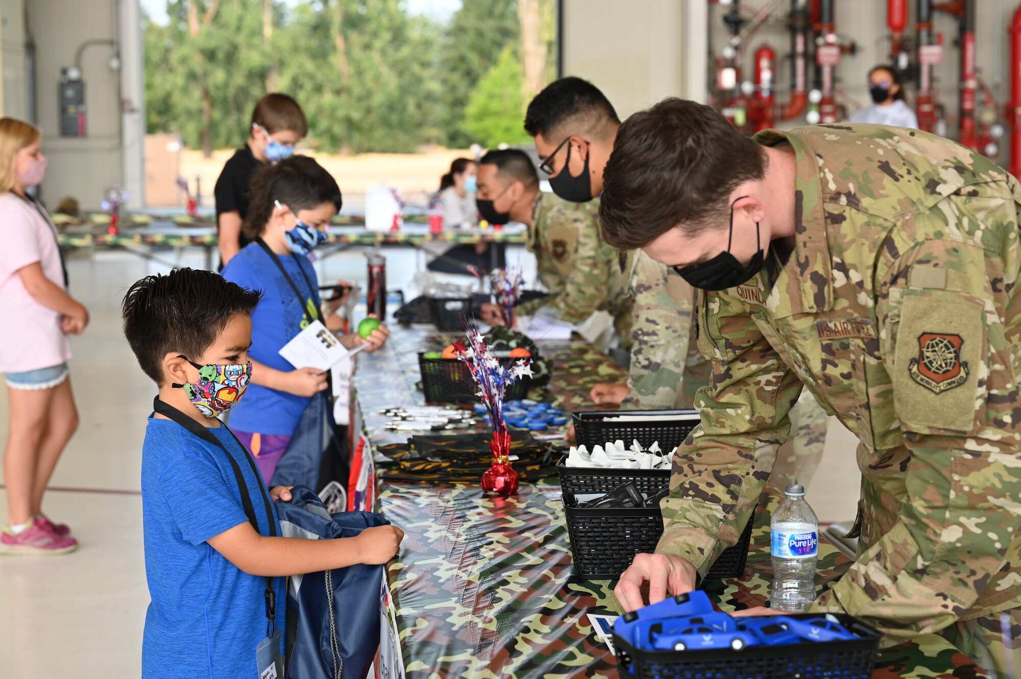 Team McChord children process through a simulated deployment line during Operation Kids Understanding Deployment Operations (KUDOs) at Joint Base Lewis-McChord, Washington, Aug. 14, 2021. The event is designed to provide a glimpse of what their military parents go through during deployments. (U.S. Air Force photo by Master Sgt. Julius Delos Reyes)