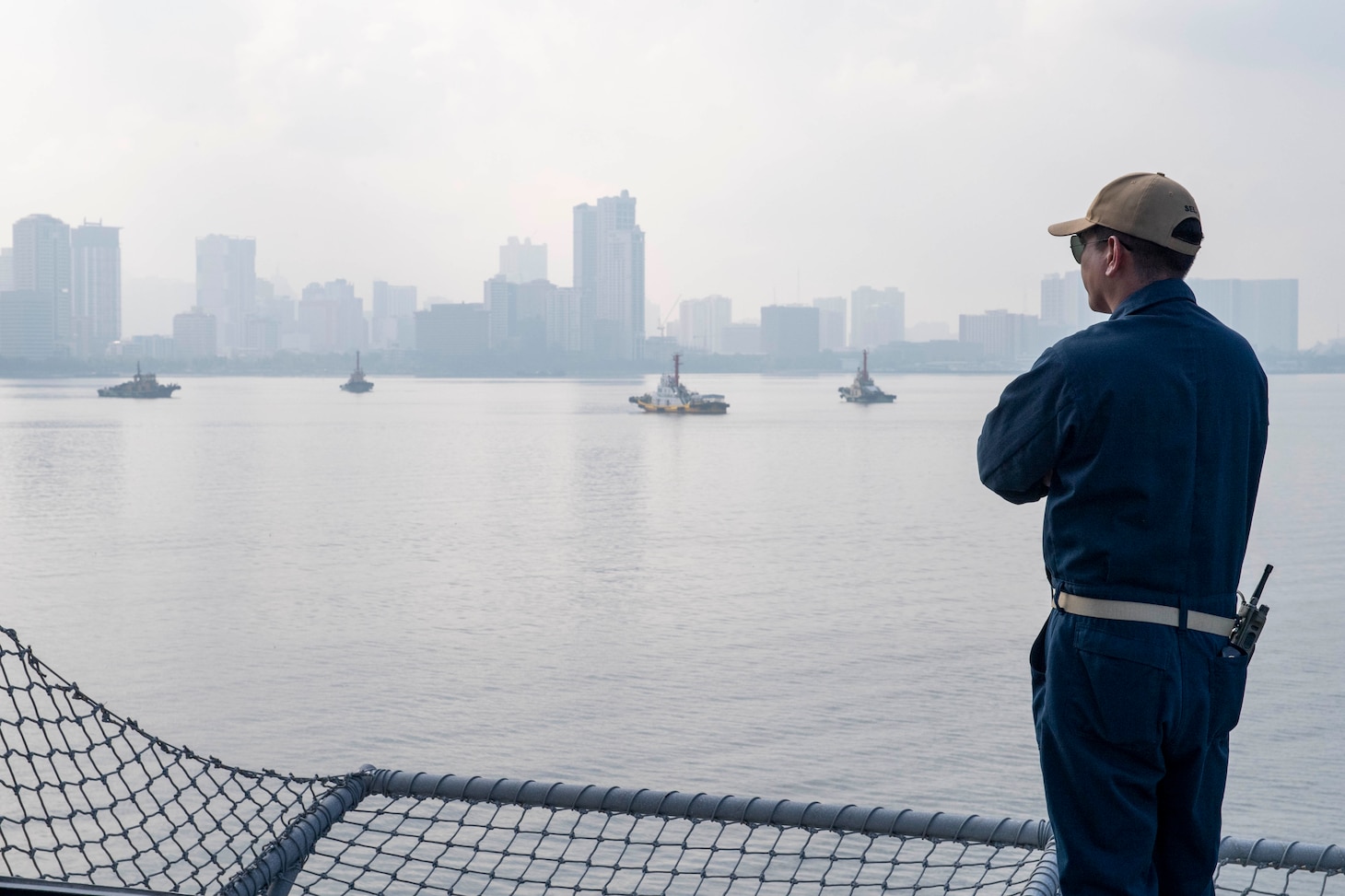 Command Senior Chief Donald Alvarado, from Tucson, Ariz., watches as Independence-variant littoral combat ship USS Charleston (LCS 18) pulls into port, Aug. 16. Charleston, part of Destroyer Squadron Seven, is on a rotational deployment operating in the U.S. 7th Fleet area of operation to enhance interoperability with partners and serve as a ready-response force in support of a free and open Indo-Pacific region.