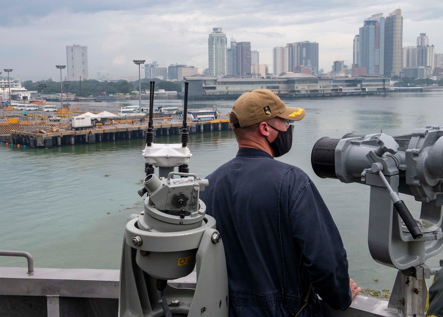 Cmdr. Joseph Burgon, commanding officer of Independence-variant littoral combat ship USS Charleston (LCS 18), looks at the city of Manila from the ship's bridge wing during a contactless port visit, Aug. 17. Charleston, part of Destroyer Squadron Seven, is on a rotational deployment operating in the U.S. 7th Fleet area of operation to enhance interoperability with partners and serve as a ready-response force in support of a free and open Indo-Pacific region.