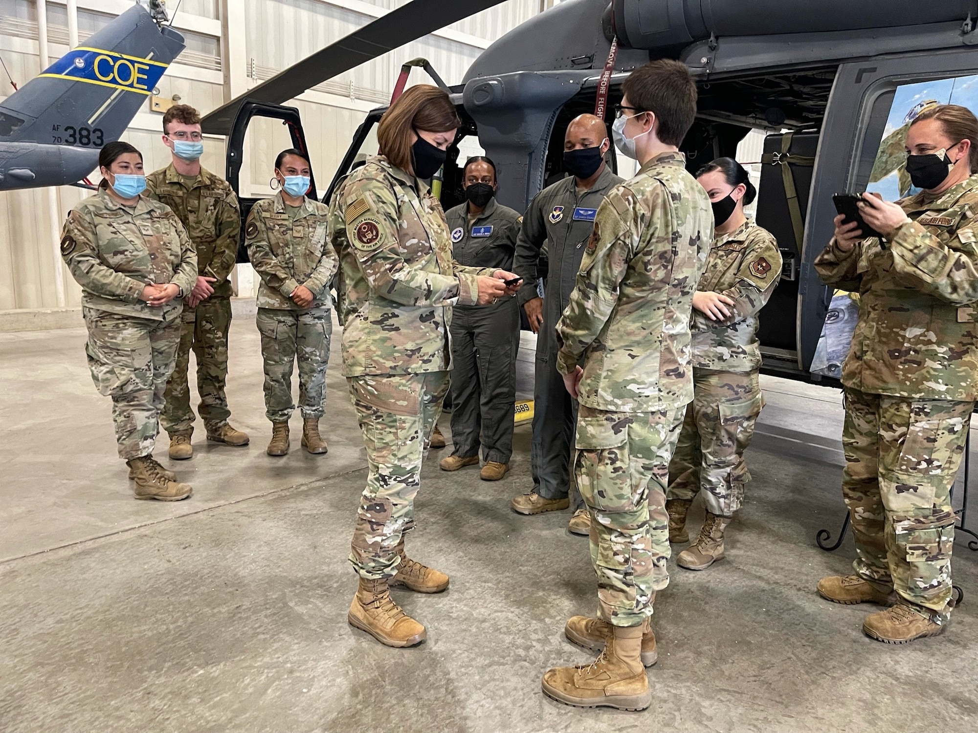 People standing by helicopter in hangar