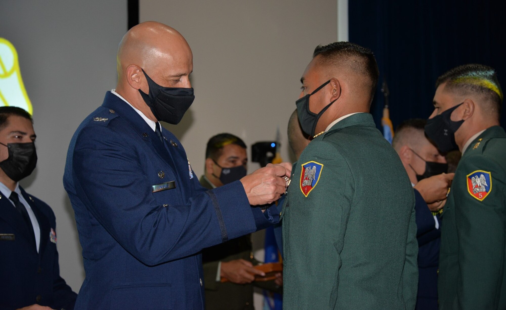 Col. Jose Jimenez, Inter-American Air Forces Academy commandant, pins the academy’s wings on a member of Class 2021-B at the graduation ceremony Aug. 10, 2021, at Joint Base San Antonio-Lackland, Texas. The class of 134 included 121 International Military Students from nine countries and 13 U.S. military members.