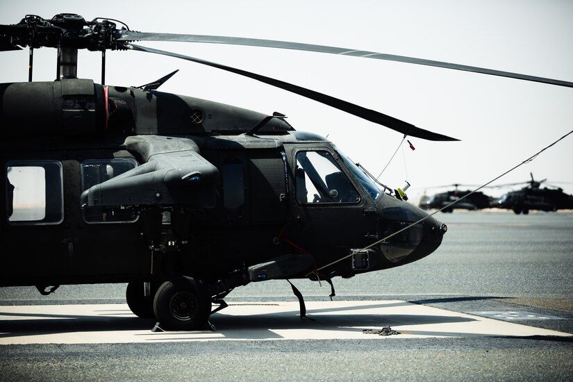 A UH-60 Blackhawk helicopter sits on the flight line at Camp Buehring, Kuwait, July 26, 2021. Nineteen Soldiers assigned to the 82nd Combat Aviation Brigade deployed to Kuwait to provide direct support to the 1100th Theater Aviation Support Maintenance Group and help alleviate a shortage of aviation contractors due to the COVID-19 pandemic. (U.S. Army photo by Sgt. Jimmie Baker)