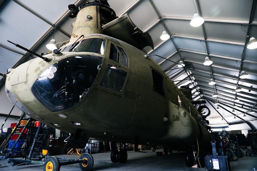 A CH-47 Chinook helicopter sits in a hanger awaiting phase maintenance at Camp Buehring, Kuwait, July 26, 2021. Phase maintenance can last anywhere between 25 and 45 days. Nineteen Soldiers assigned to the 82nd Combat Aviation Brigade deployed to Kuwait to provide direct support to the 1100th Theater Aviation Support Maintenance Group and help alleviate a shortage of aviation contractors due to the COVID-19 pandemic. (U.S. Army photo by Sgt. Jimmie Baker)