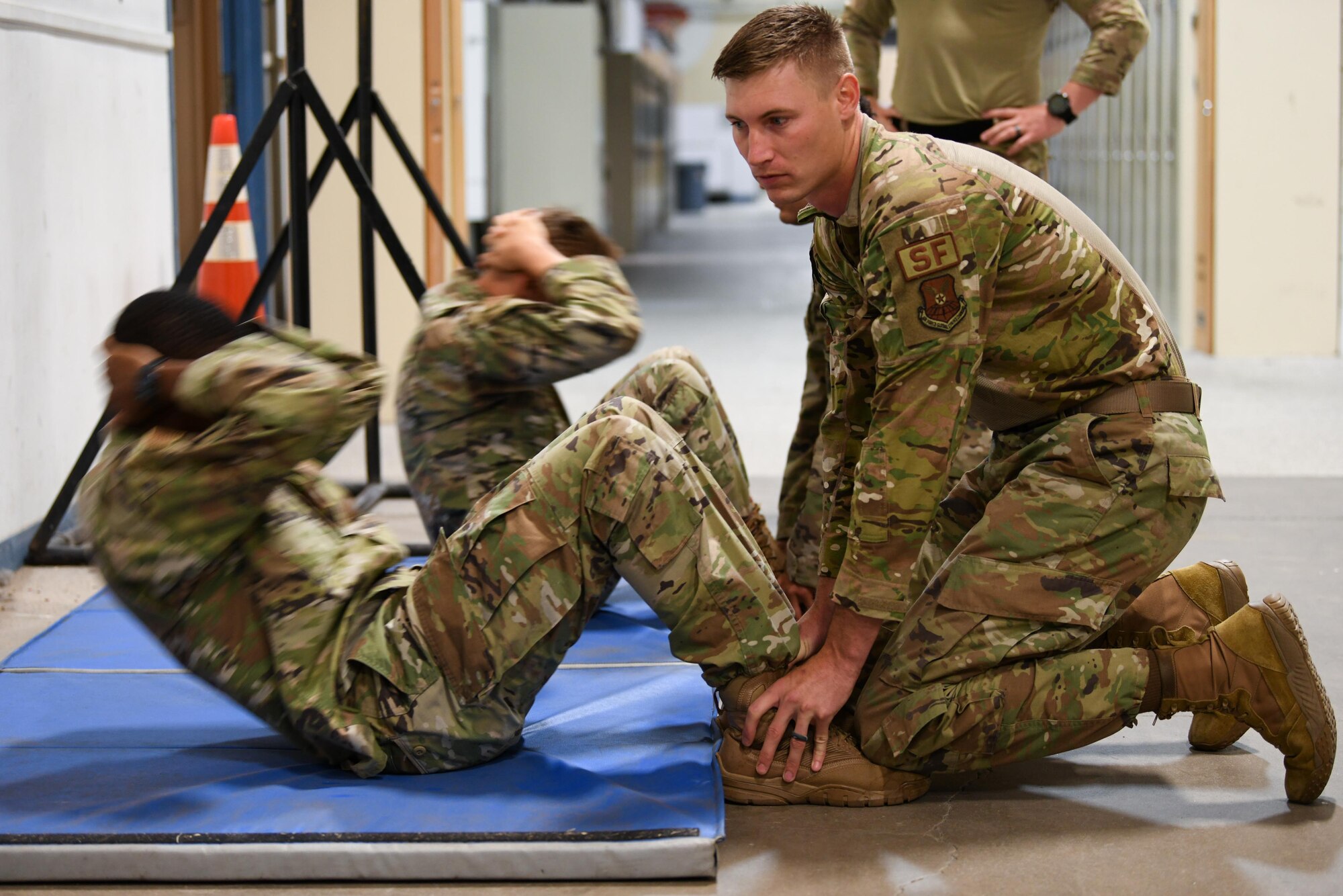 Airmen from the 90th Security Forces Squadron practice the sit-up portion of the Global Strike Challenge tryouts at F.E. Warren Air Force Base, Wyoming, June 8, 2021. Teams from across Air Force Global Strike Command will compete in events that require physical strength and endurance to prove their capabilities on the team. (U.S. Air Force photo by Airman 1st Class Faith Iris MacIlvaine)
