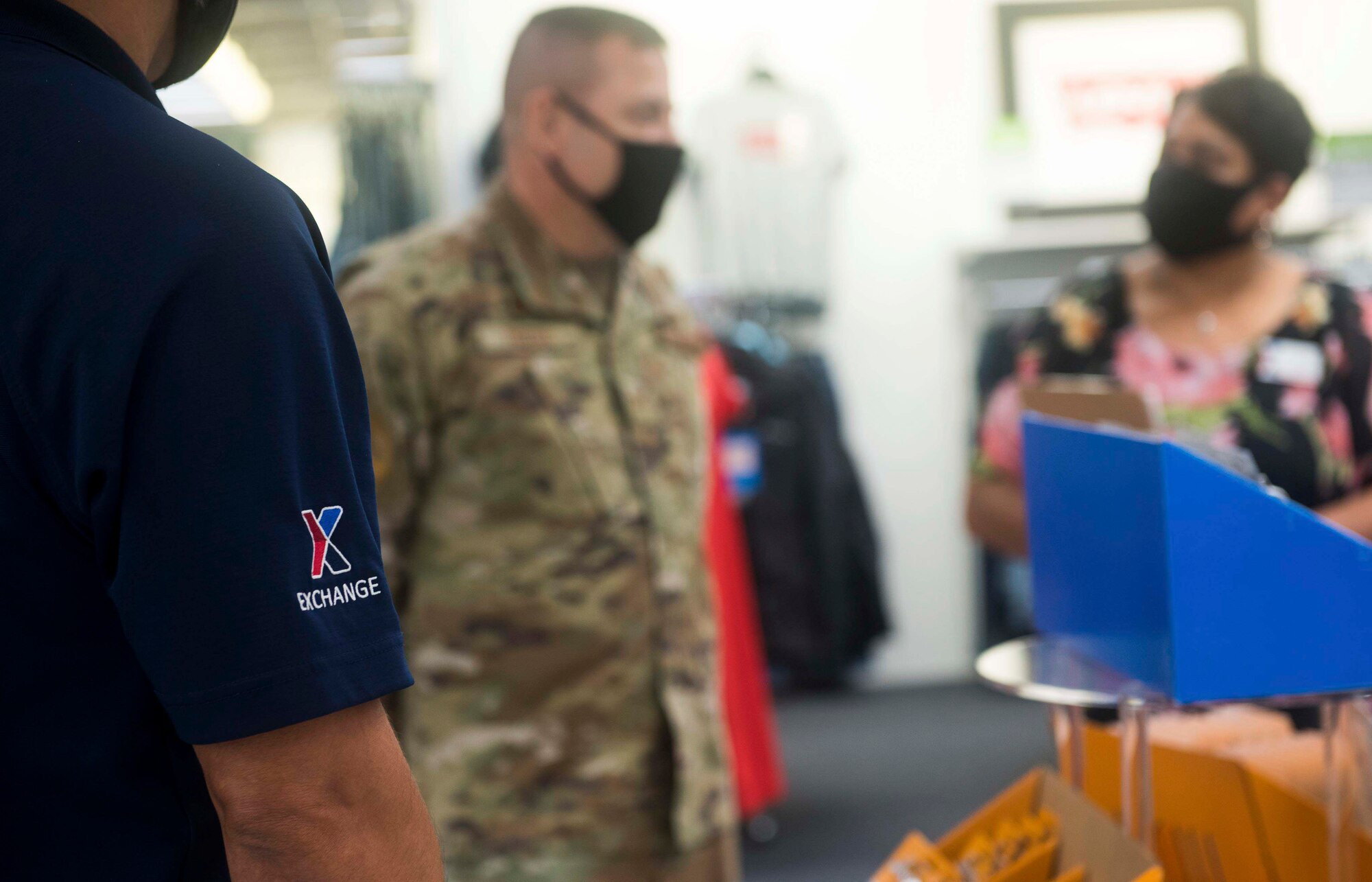 A military member listens to a BX worker at the BX.