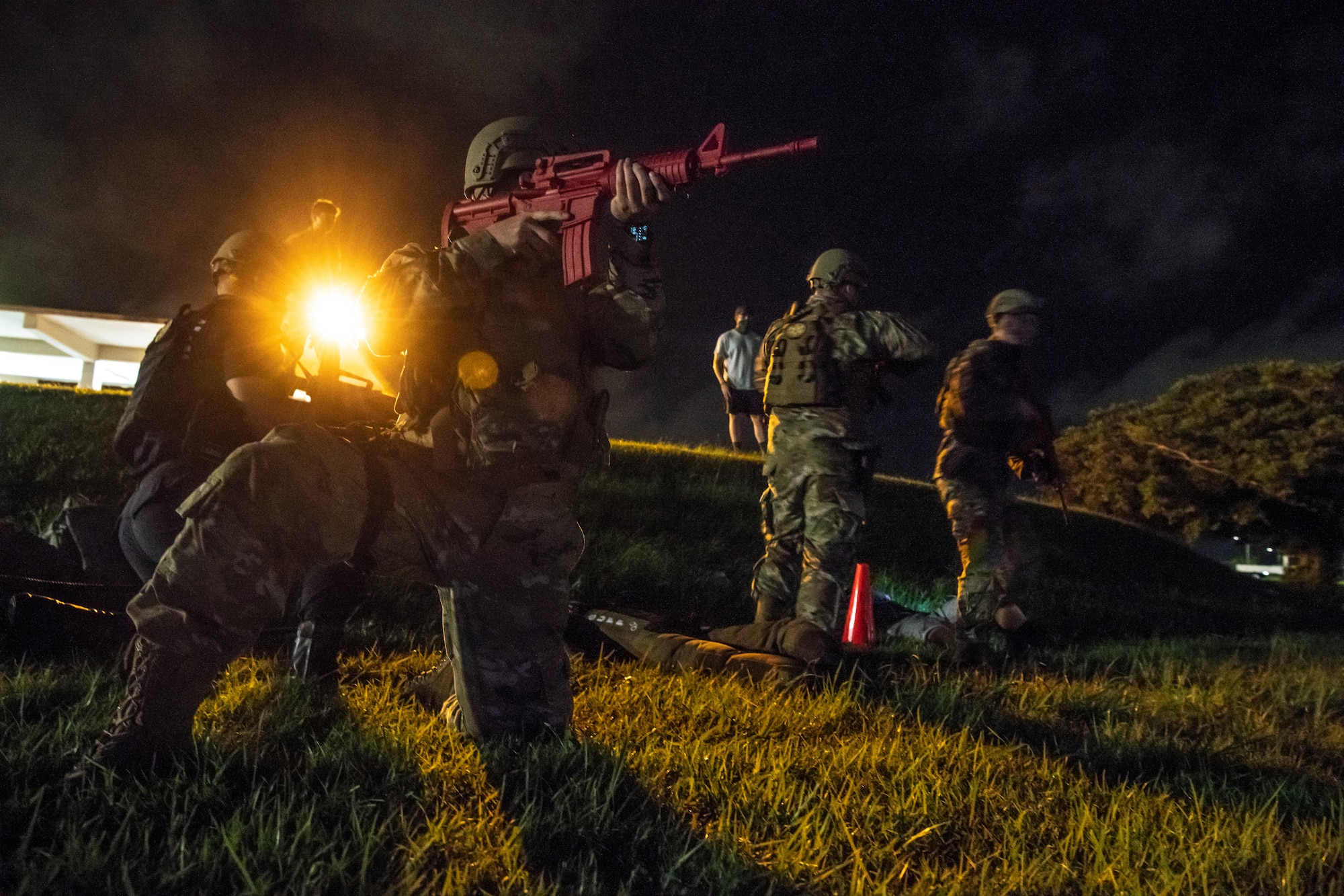 Defenders from the 18th Security Forces Squadron provide casualty care while taking simulated fire during the Defender Flight of the Quarter Challenge on Kadena Air Base, Japan, Aug. 12, 2021. Each quarter the 18th SFS conducts the Defender Challenge to highlight superior performers for each flight, hone skills and boost unit morale. (U.S. Air Force photo by Tech. Sgt. Micaiah Anthony)