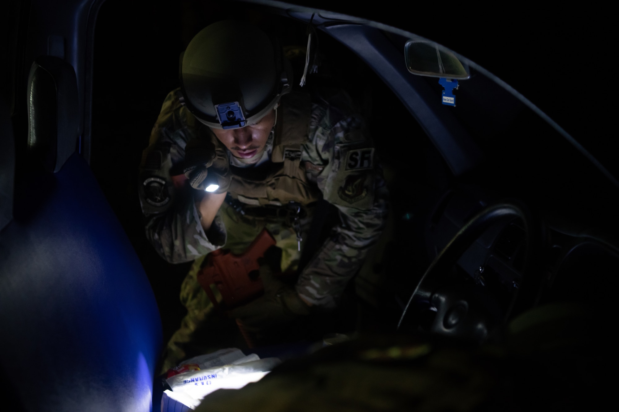 U.S. Air Force Senior Airman Torres Salvador, 18th Security Forces Squadron alarm monitor, searches a vehicle during the Defender Flight of the Quarter Challenge on Kadena Air Base, Japan, Aug. 12, 2021. The vehicle search was conducted as part of a high-risk traffic stop scenario. (U.S. Air Force photo by Tech. Sgt. Micaiah Anthony)
