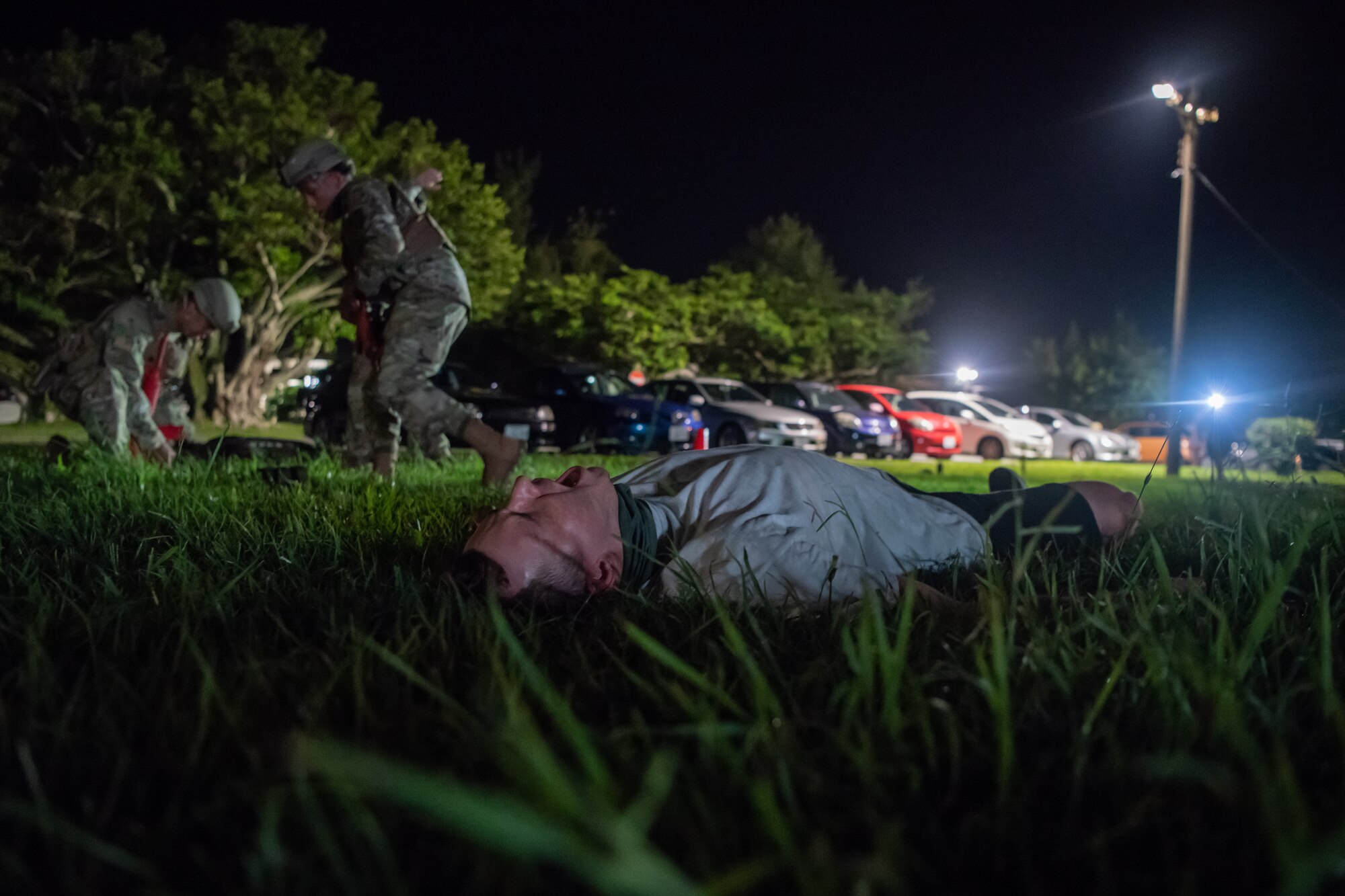 U.S. Air Force Senior Airman Cord Wickander, 18th Security Forces Squadron response force leader, calls for help during the Defender Flight of the Quarter Challenge on Kadena Air Base, Japan, Aug. 12, 2021. Wickander acted as a simulated patient with a wounded arm. The scenario required defenders to transport two patients and medical equipment across a field while under simulated fire. (U.S. Air Force photo by Tech. Sgt. Micaiah Anthony)