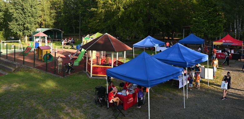 People walk around Community Cares Partners Party in the Park event on Vogelweh Military Complex, Germany, Aug. 12, 2021. The 86th Force Support Squadron hosted the Party in the Park to bring members of the Kaiserslautern Military Community together to enjoy food, music and learn about community resources. (U.S. Air Force photo by Senior Airman Thomas Karol)