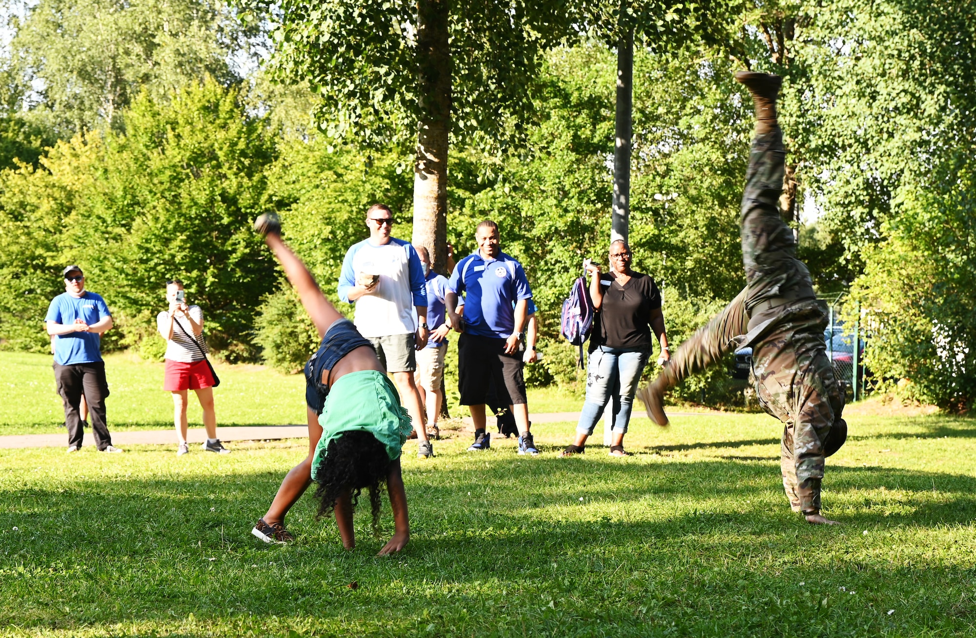 U.S. Air Force Col. Amy Glisson, 86th Mission Support Group commander, does a cartwheel at the Community Cares Partners Party in the Park event at Vogelweh Military Complex, Germany, Aug. 12, 2021. Glisson provided opening remarks to community members to kick-off the helping agencies event. The party allowed service members and their families to enjoy food and music while learning about resources provided by agencies from the Kaiserslautern Military Community. (U.S. Air Force photo by Senior Airman Thomas Karol)