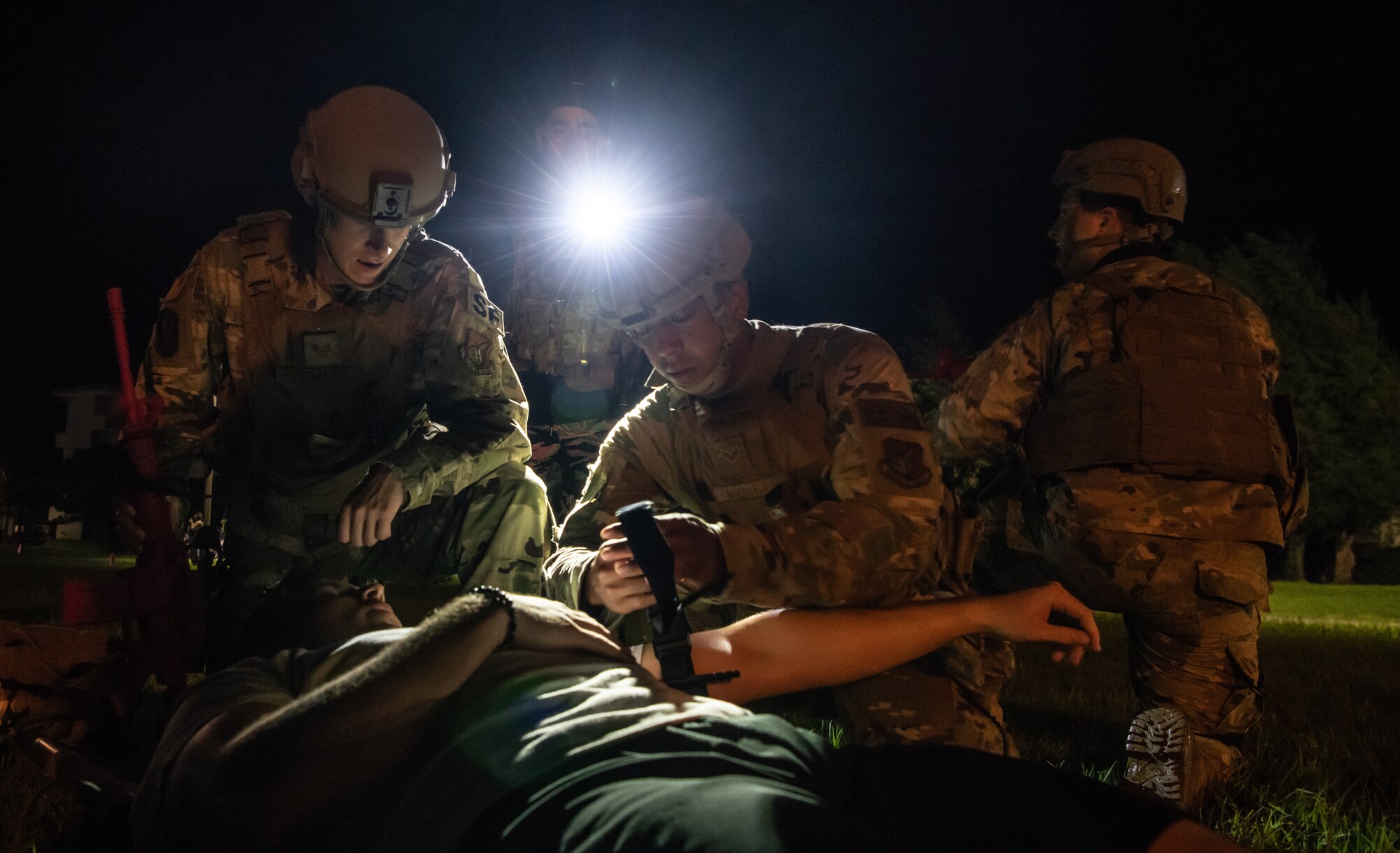 U.S. Air Force Airmen from the 18th Security Forces Squadron provide aid to a simulated patient during the Defender Flight of the Quarter Challenge on Kadena Air Base, Japan, Aug. 12, 2021. The challenge consisted of four main stations where participants were tested on field stripping weapons in low-light conditions, providing medical care under fire, room clearing, and conducting a high-risk traffic stop. (U.S. Air Force photo by Tech. Sgt. Micaiah Anthony)