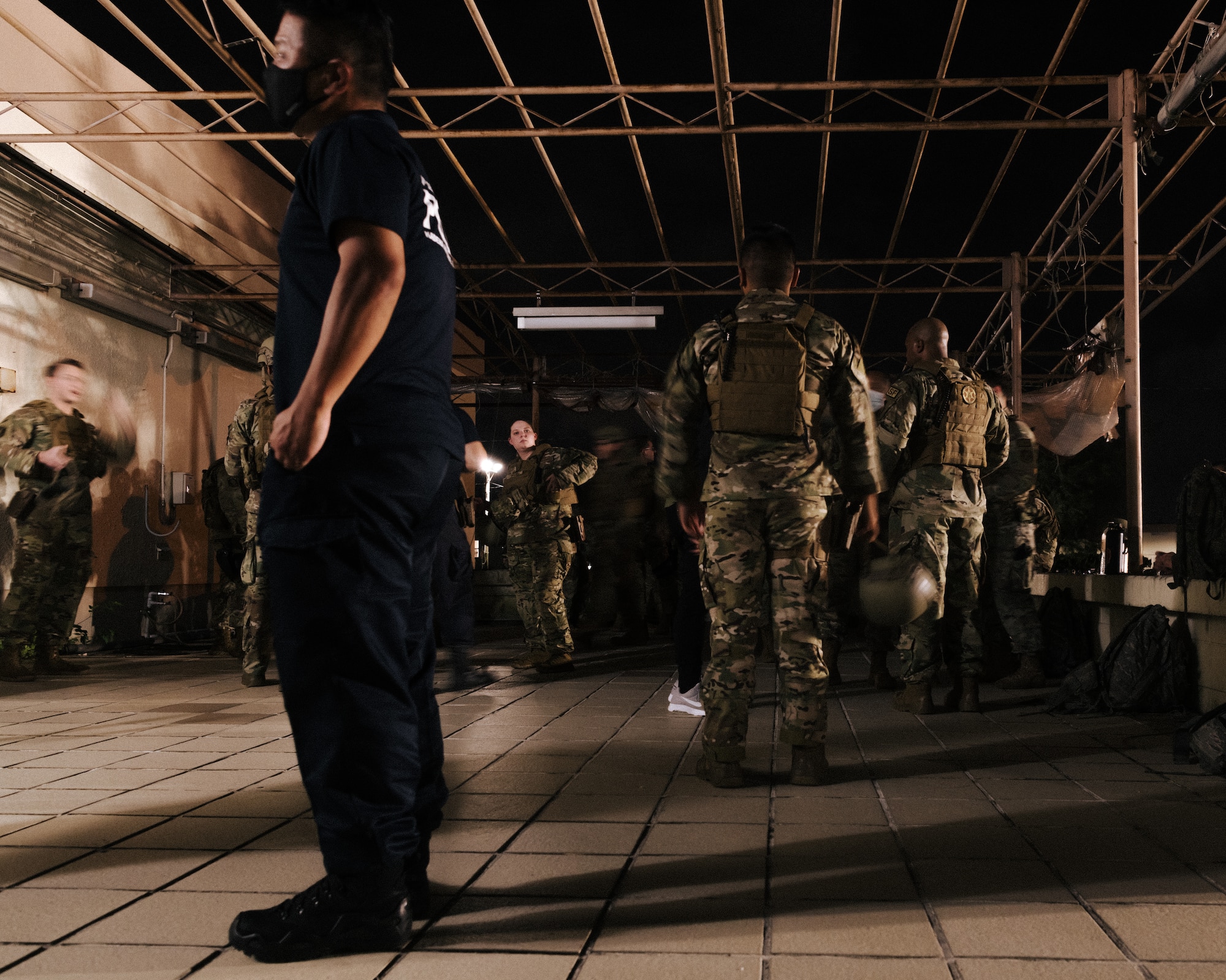 Defenders from the 18th Security Forces Squadron wait for the Defender Flight of the Quarter Challenge to start on Kadena Air Base, Japan, Aug. 12, 2021. The challenge consisted of four main stations where participants were tested on field stripping weapons in low-light conditions, providing medical care under fire, room clearing, and conducting a high-risk traffic stop. (U.S. Air Force photo by Airman 1st Class Stephen Pulter)