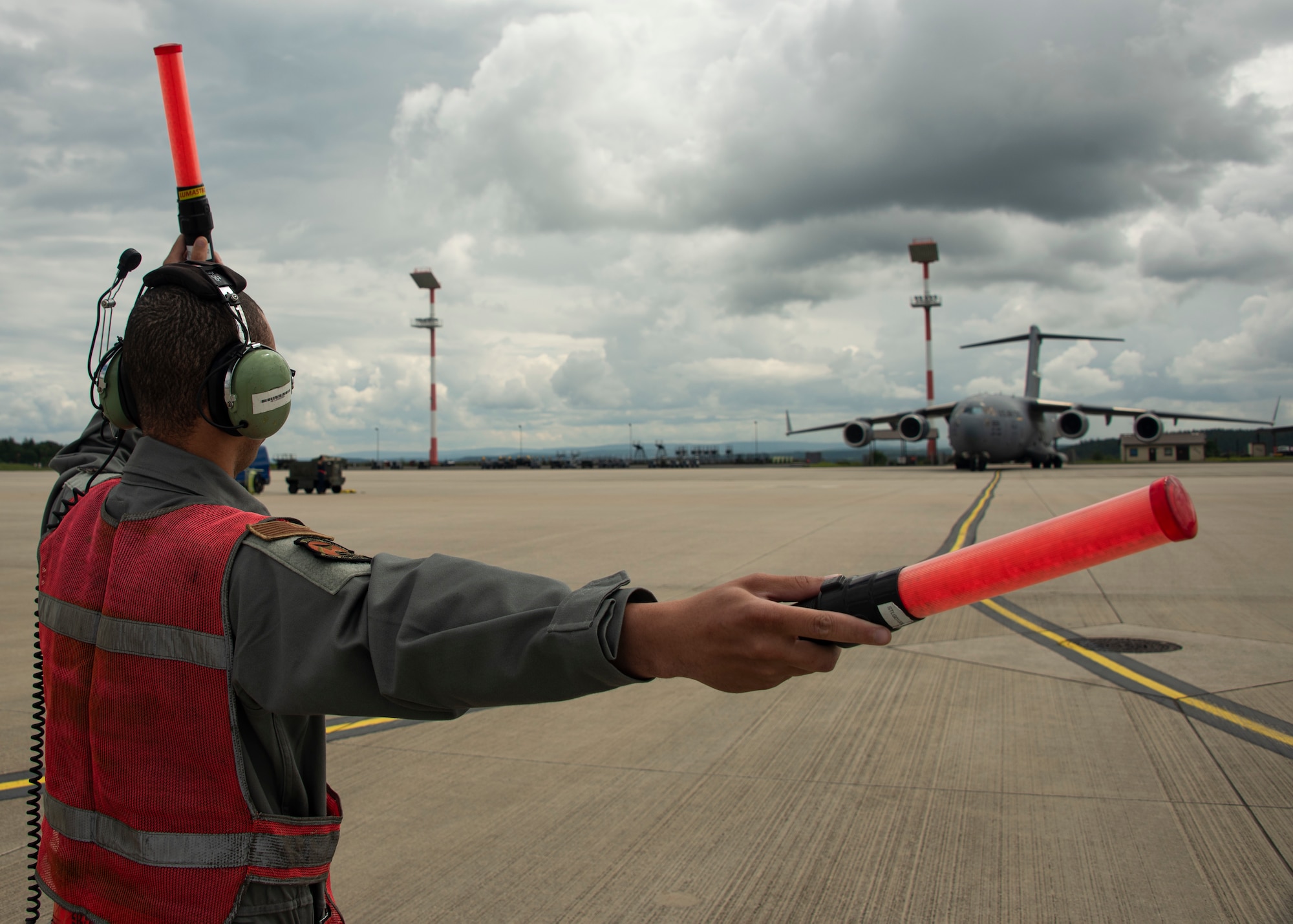 U.S. Air Force Senior Airman Alberto Lara, 726th AMS crew chief, marshals a U.S. Air Force C-17 Globemaster III cargo aircraft on Spangdahlem Air Base, Germany, Aug. 5, 2021.